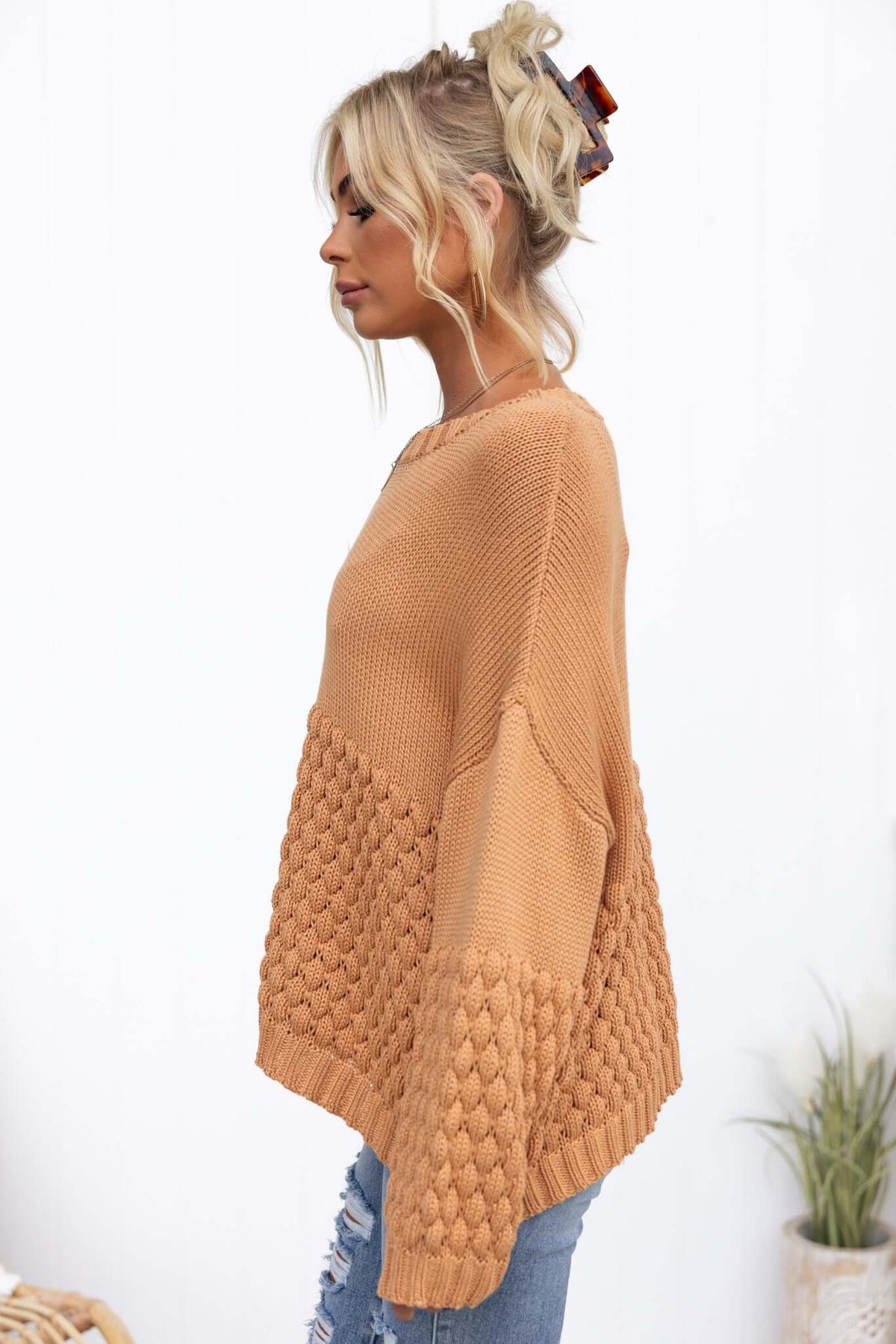 Profile view of a woman wearing a cozy, camel-colored Hamden Jumper with textured knit design and relaxed fit.