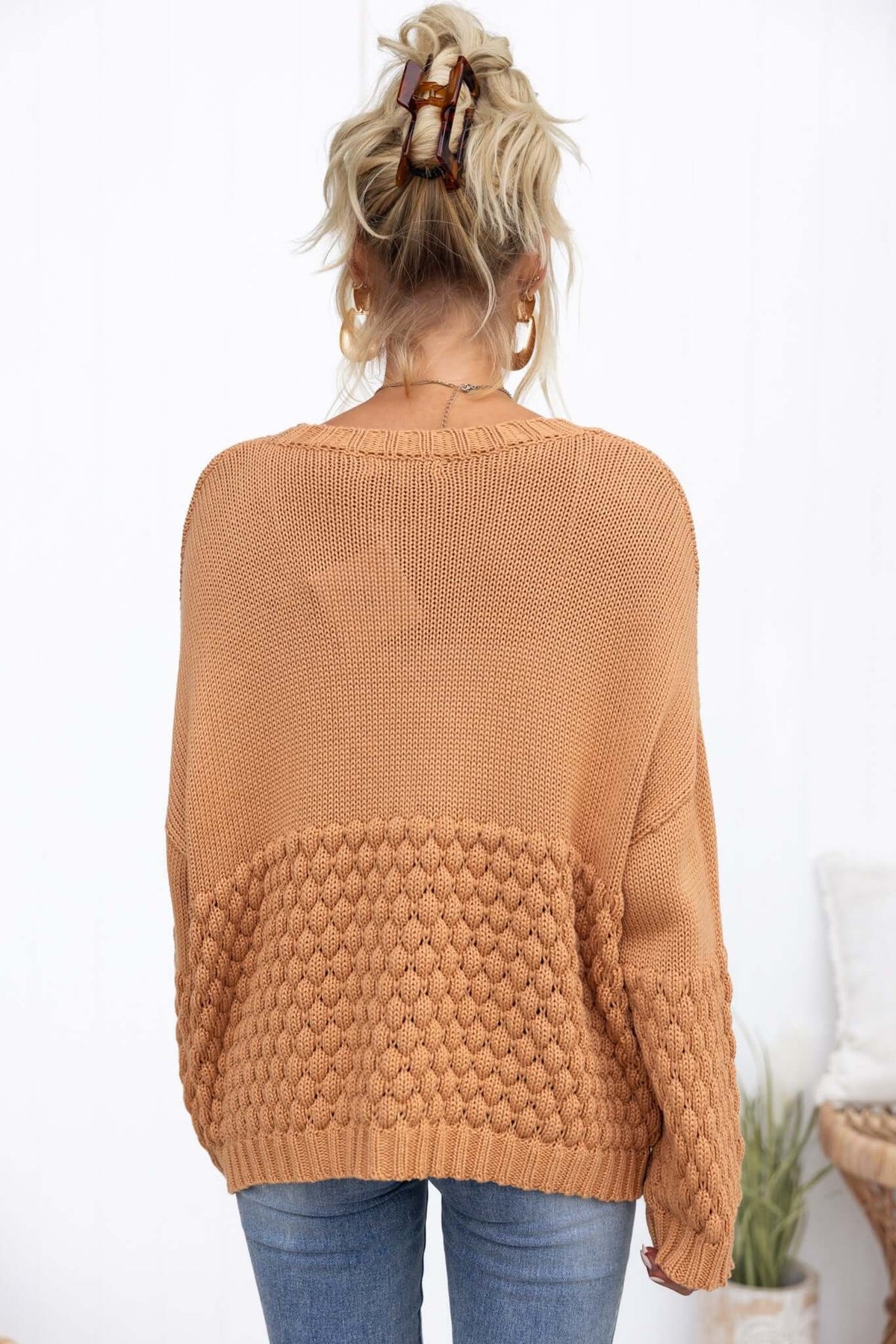 Back view of Hamden Jumper in warm orange, showcasing knit texture and loose fit, styled with casual jeans.