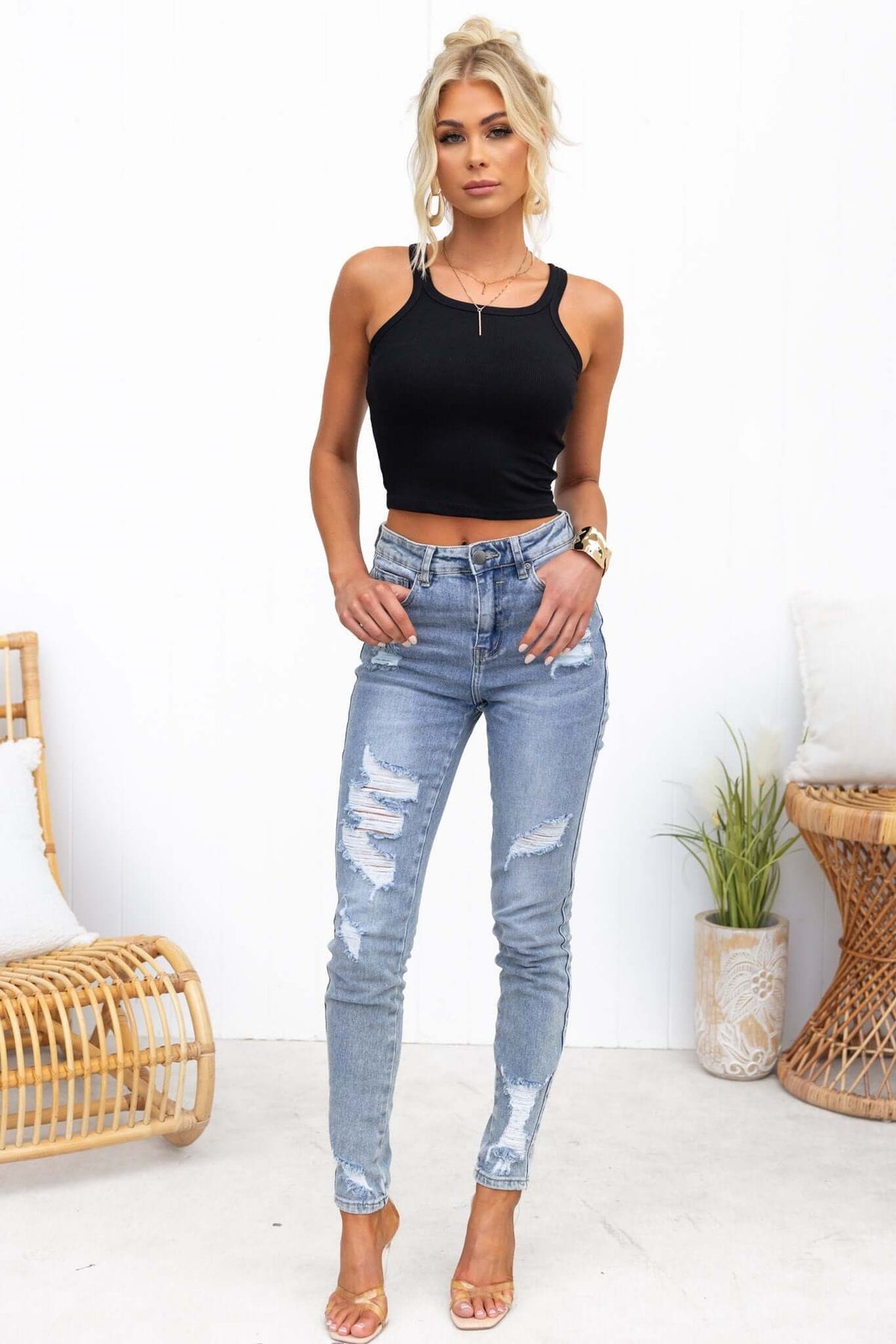 Model wearing a stylish black ribbed Perry Top paired with distressed blue jeans and sandals.