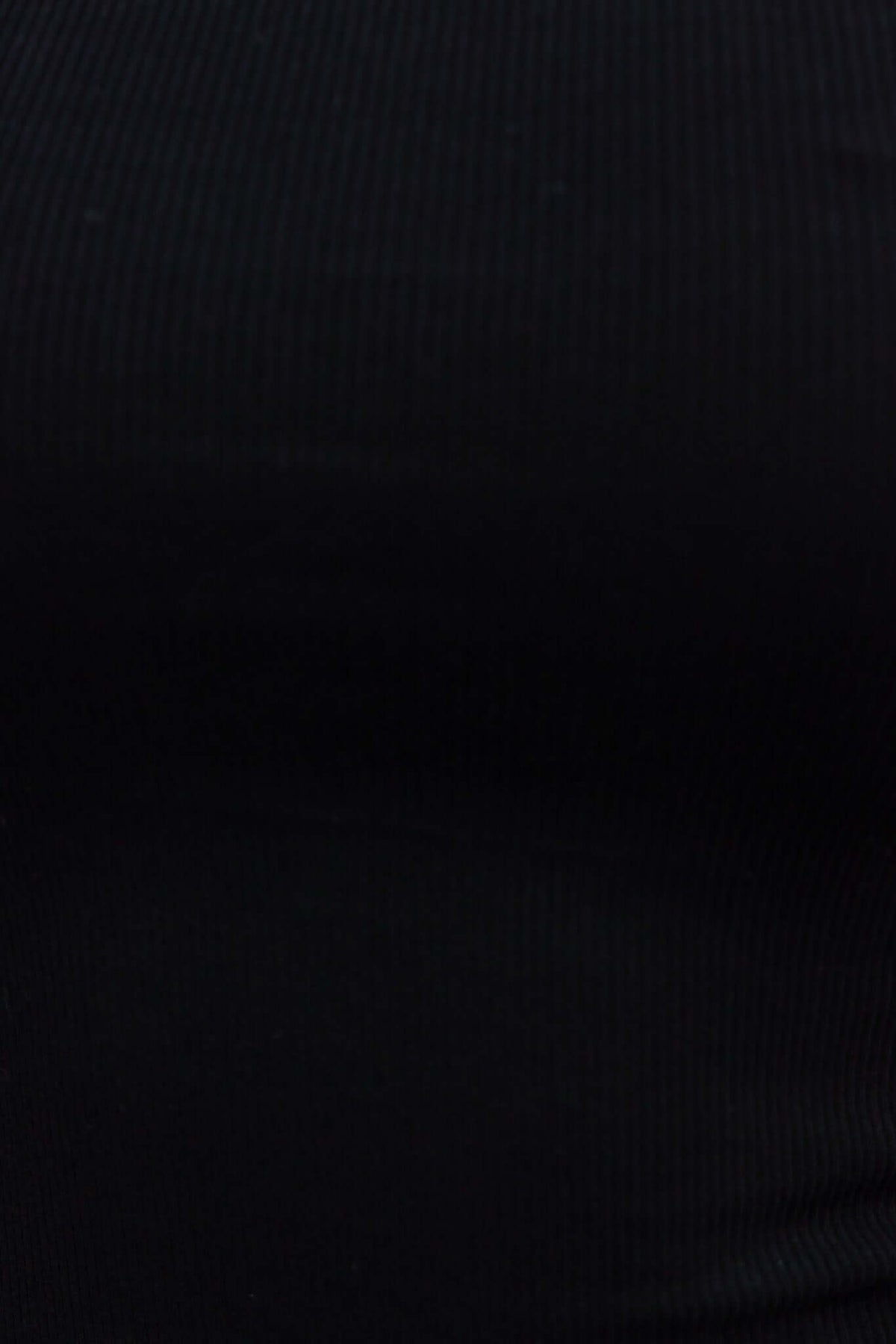 Close-up view of a black ribbed top with a round neckline and stretchy fabric, suitable for casual wear.