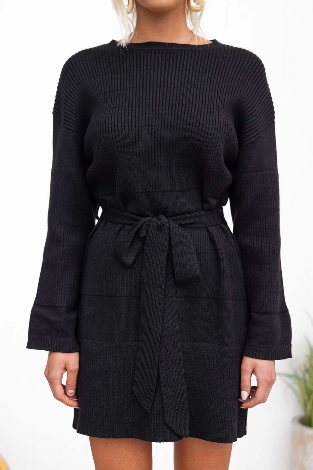 Black ribbed dress with round neckline and removable tie, worn by a model.