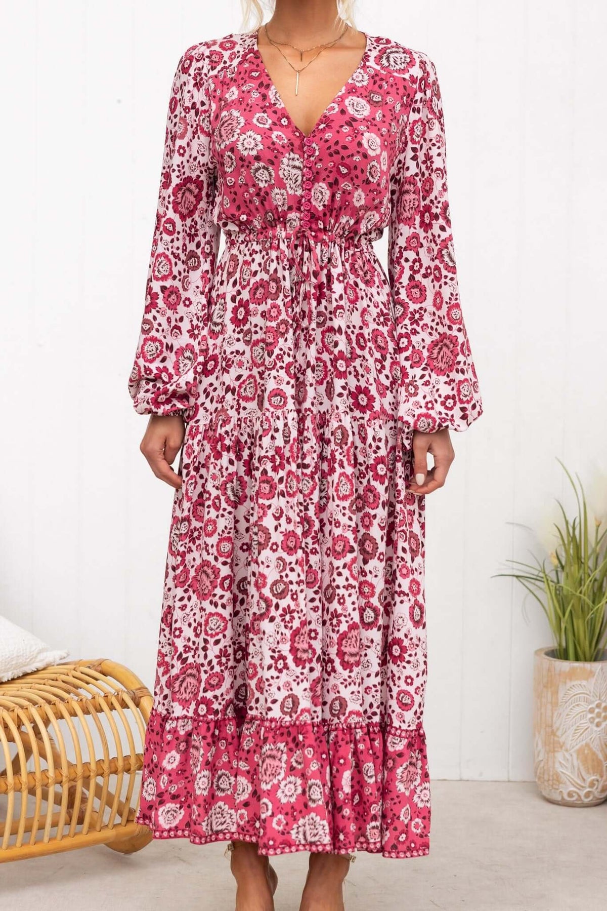 Woman wearing Sarzana Maxi Dress featuring floral pattern, elastic sleeves, and drawstring waist.