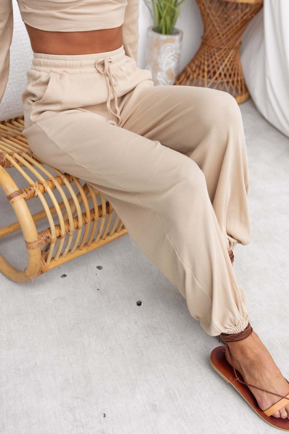 Stylish mid-high waist Micah Pants with elastic waistband, cuffs, and pockets in a soft beige color.