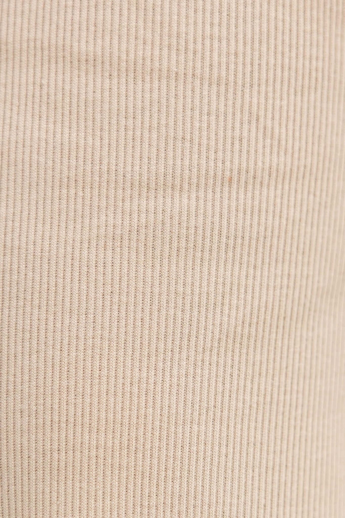 Close-up of the textured fabric of Micah Pants in a beige color.