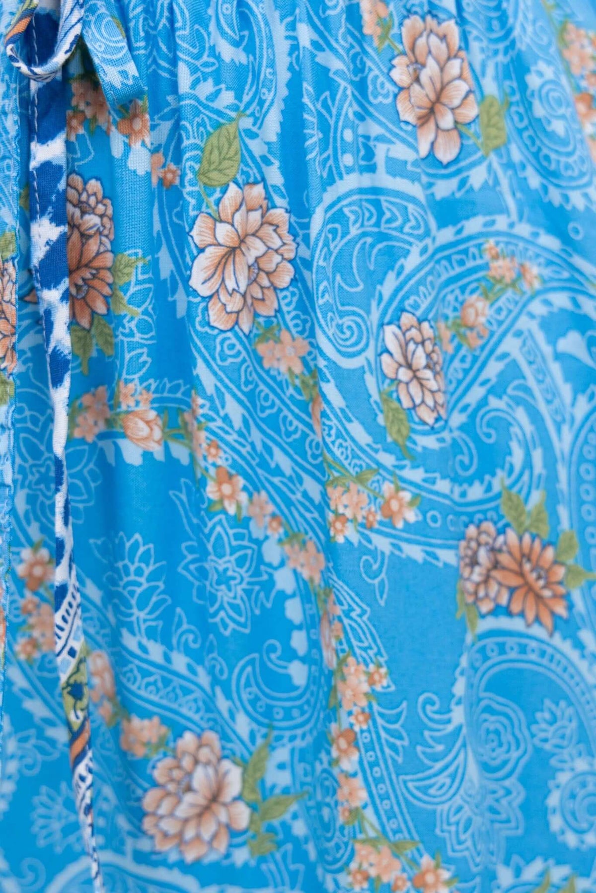 Close-up of Darian Maxi Skirt featuring a floral paisley print in blue and orange hues.