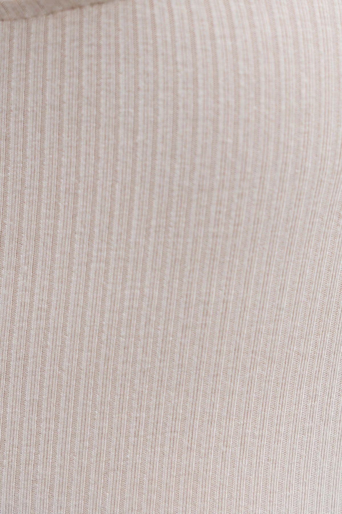 Close-up of the Nola Bodysuit fabric showing ribbed texture in a neutral beige color, highlighting its stretch material.