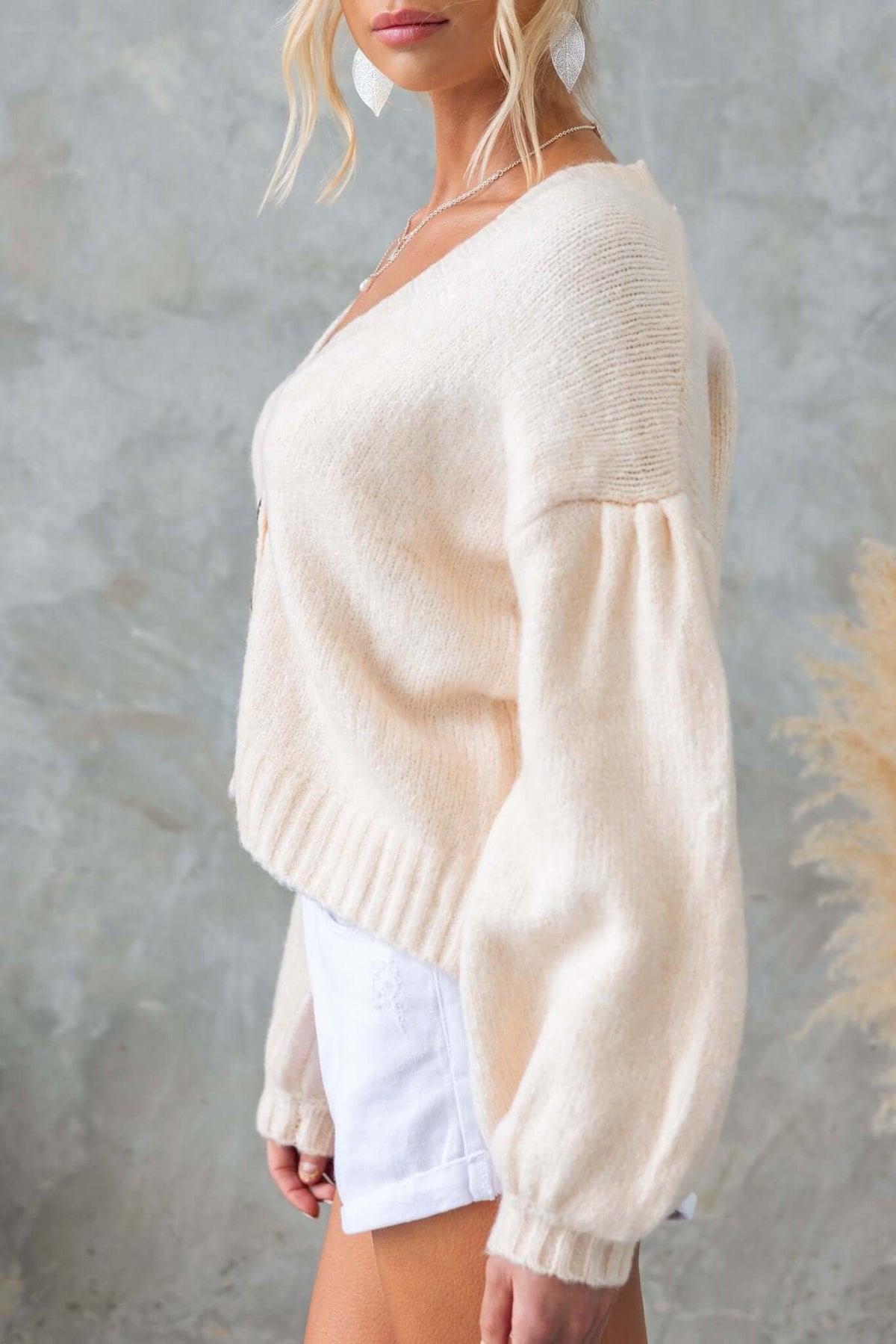 Side view of the Irvine Cardigan featuring a V-neckline, button-up front, and relaxed fit, styled with shorts.
