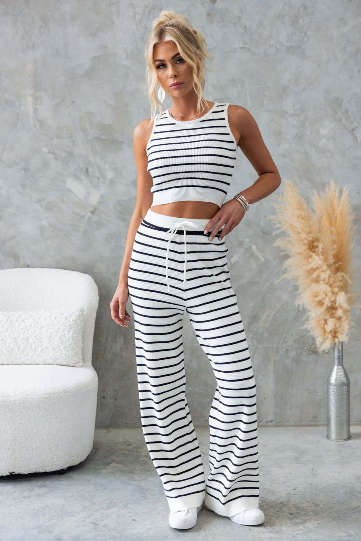 Model wearing Nowlan Pants with mid-high waist, drop crotch, and elastic waistband in a stylish striped design.
