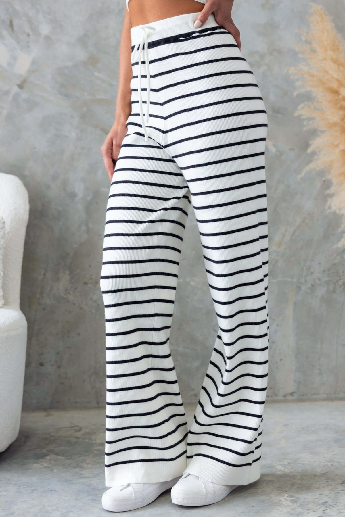 Nowlan Pants with mid-high waist and drop crotch design, featuring striped ribbed knit material and elastic drawstring waistband.