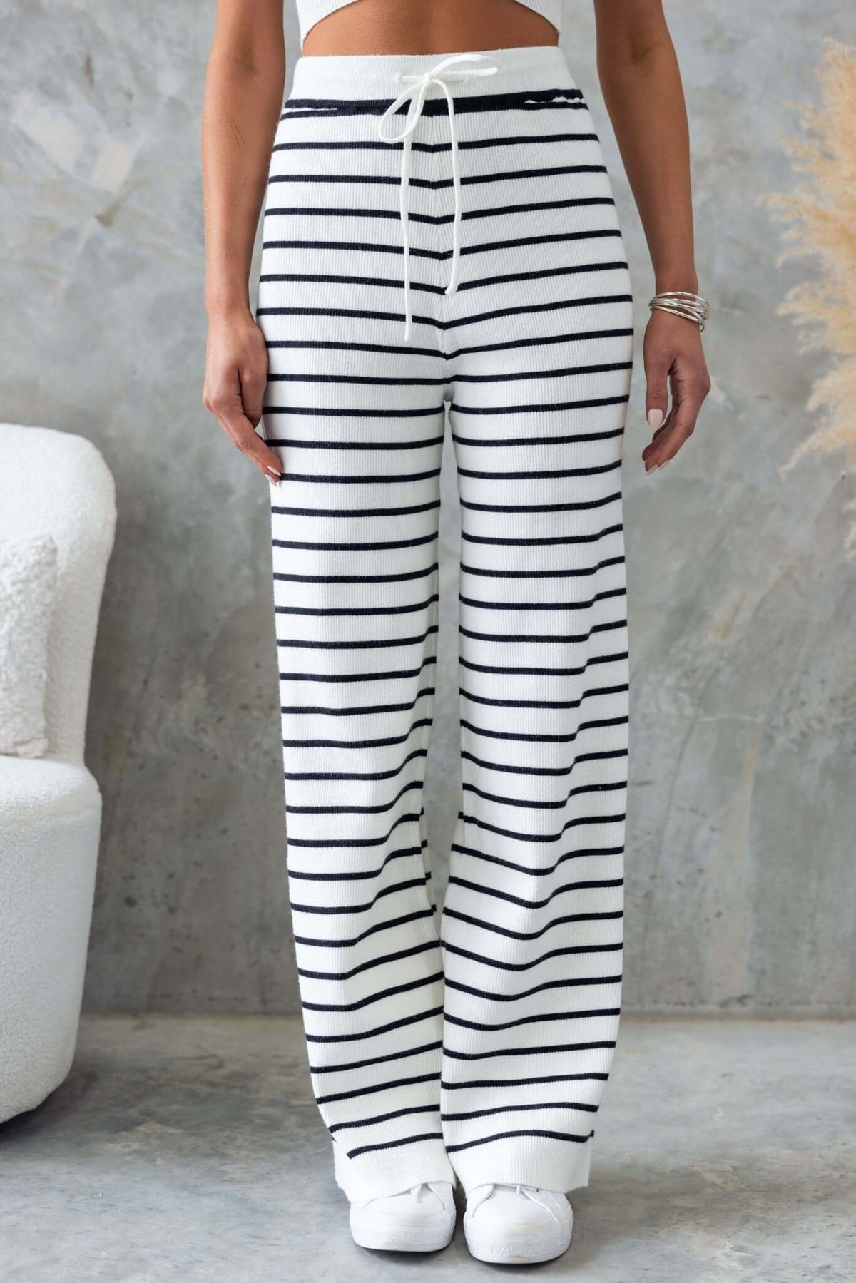 Nowlan Pants featuring a mid-high waist, drop crotch style, elastic waistband, and a comfy ribbed knit material with stripes.