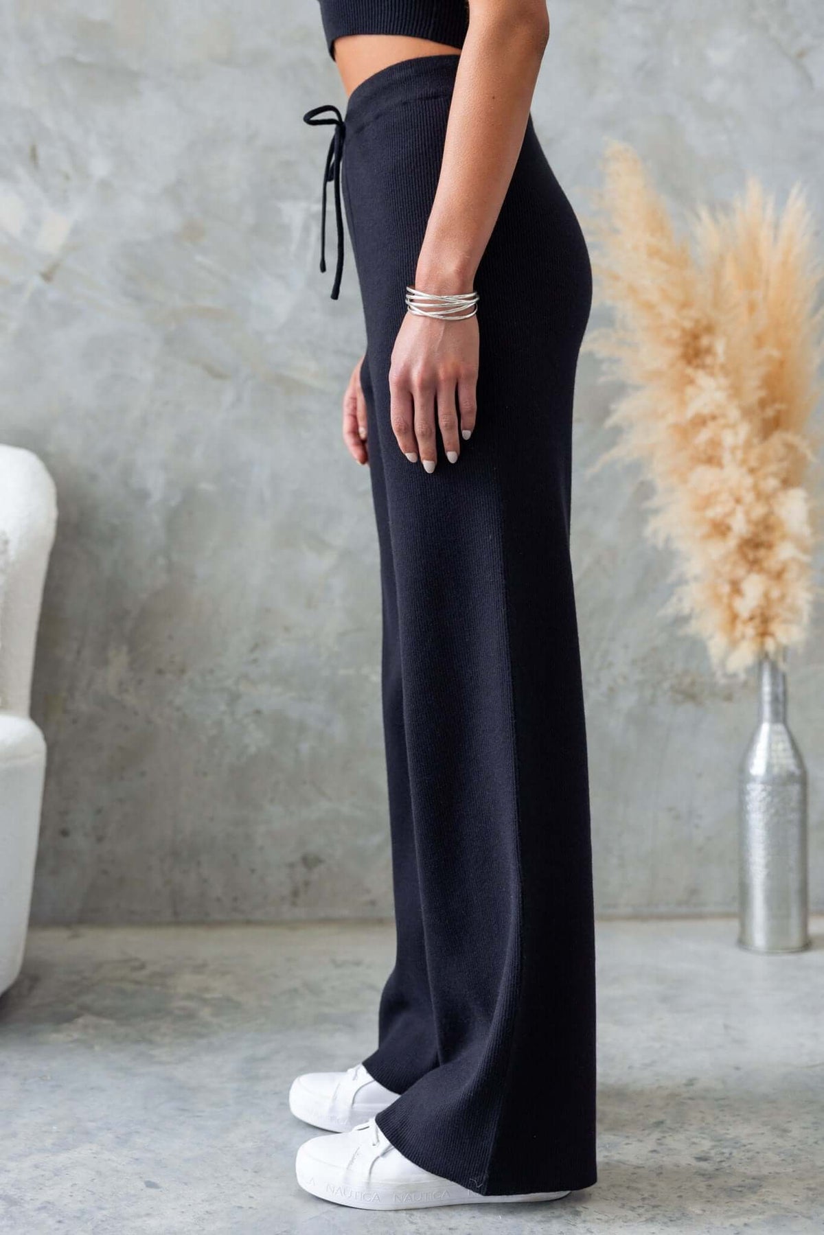 Side view of Nowlan Pants in black, showcasing mid-high waist, drop crotch style, and elastic waistband with drawstring.