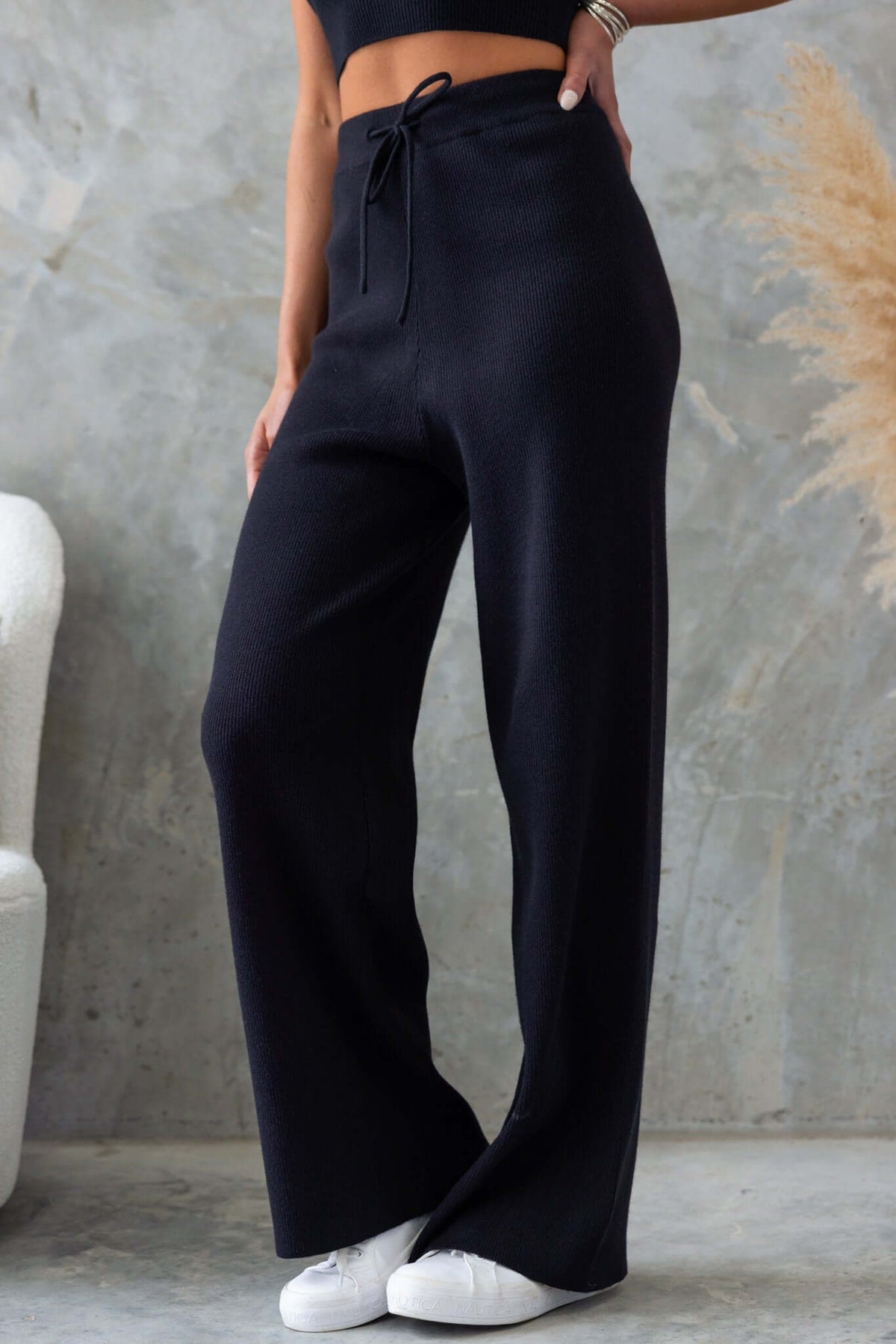 Black Nowlan Pants with mid-high waist and drop crotch style, featuring an elastic drawstring waistband.