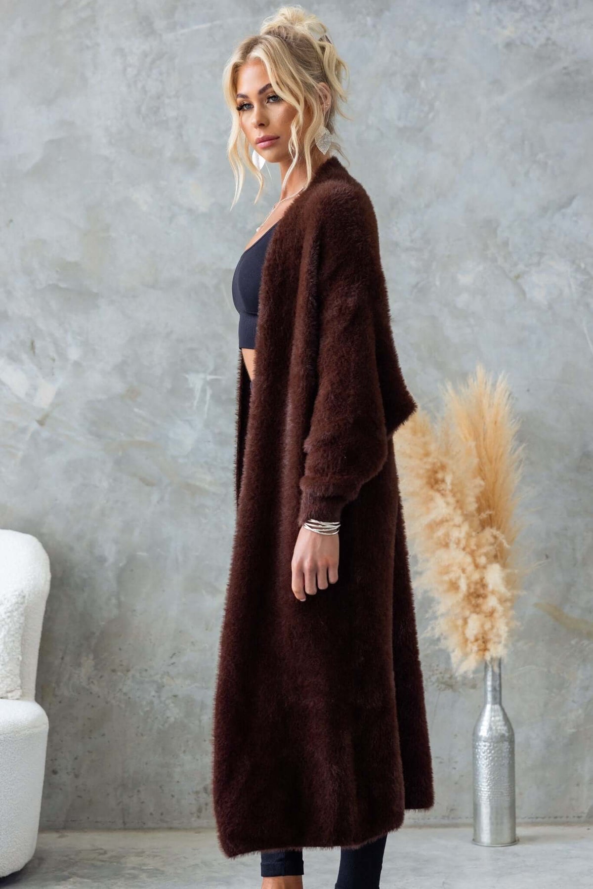 Model wearing a longline brown fluffy knit Salem Cardigan styled with a black outfit, showcasing its relaxed fit.