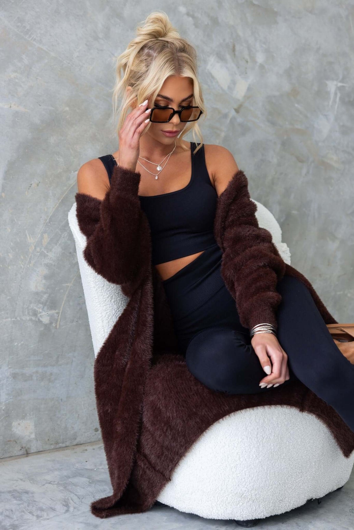 Model wearing a longline brown Salem Cardigan over a black outfit, showcasing a fluffy knit texture and relaxed style.