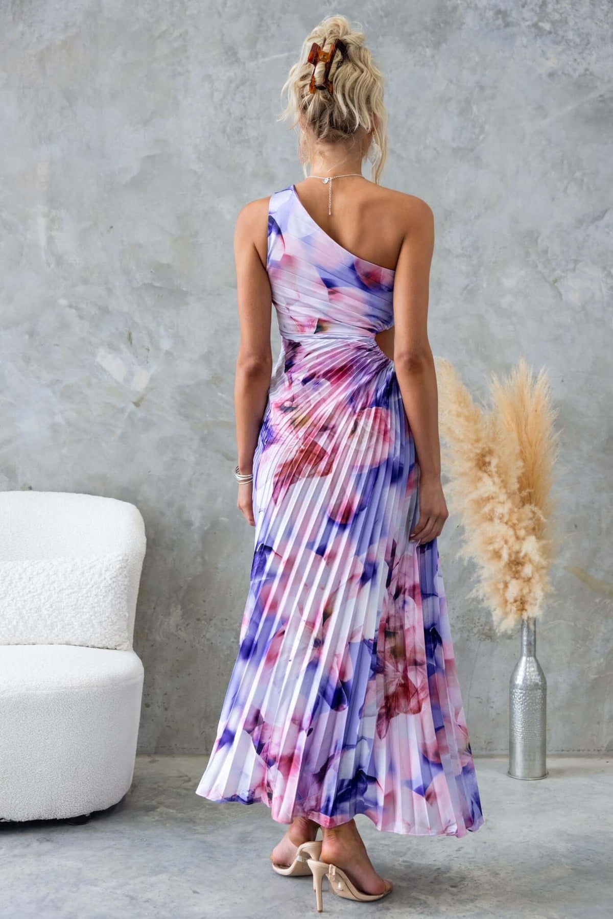 Back view of Ottile Maxi Dress featuring a one-shoulder neckline and accordion pleats in floral design.
