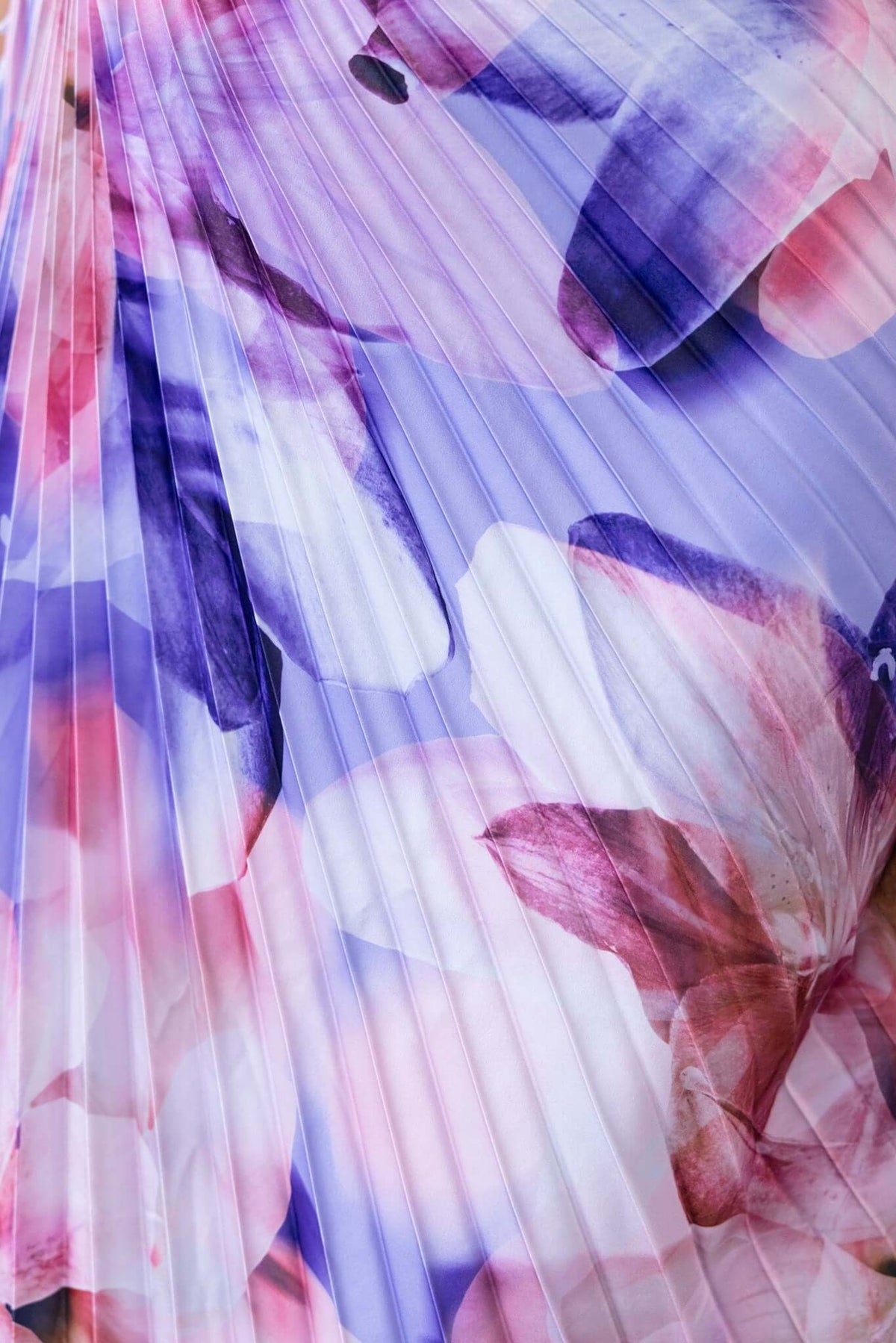 Close-up of accordion pleat fabric in purple and pink floral design, showcasing the vibrant colors and texture.