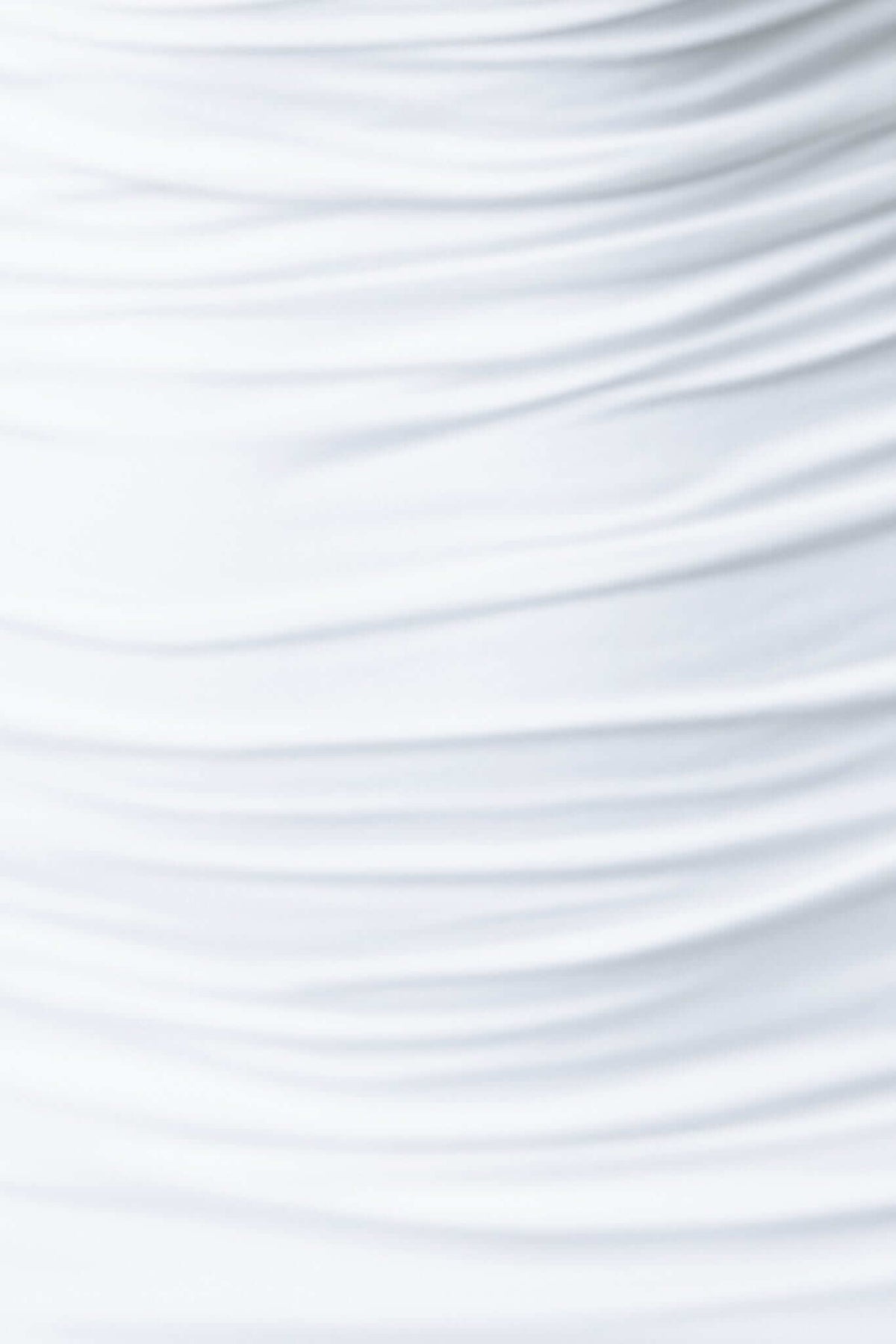 Close-up of slinky white bodycon dress fabric with soft ruching and smooth texture.