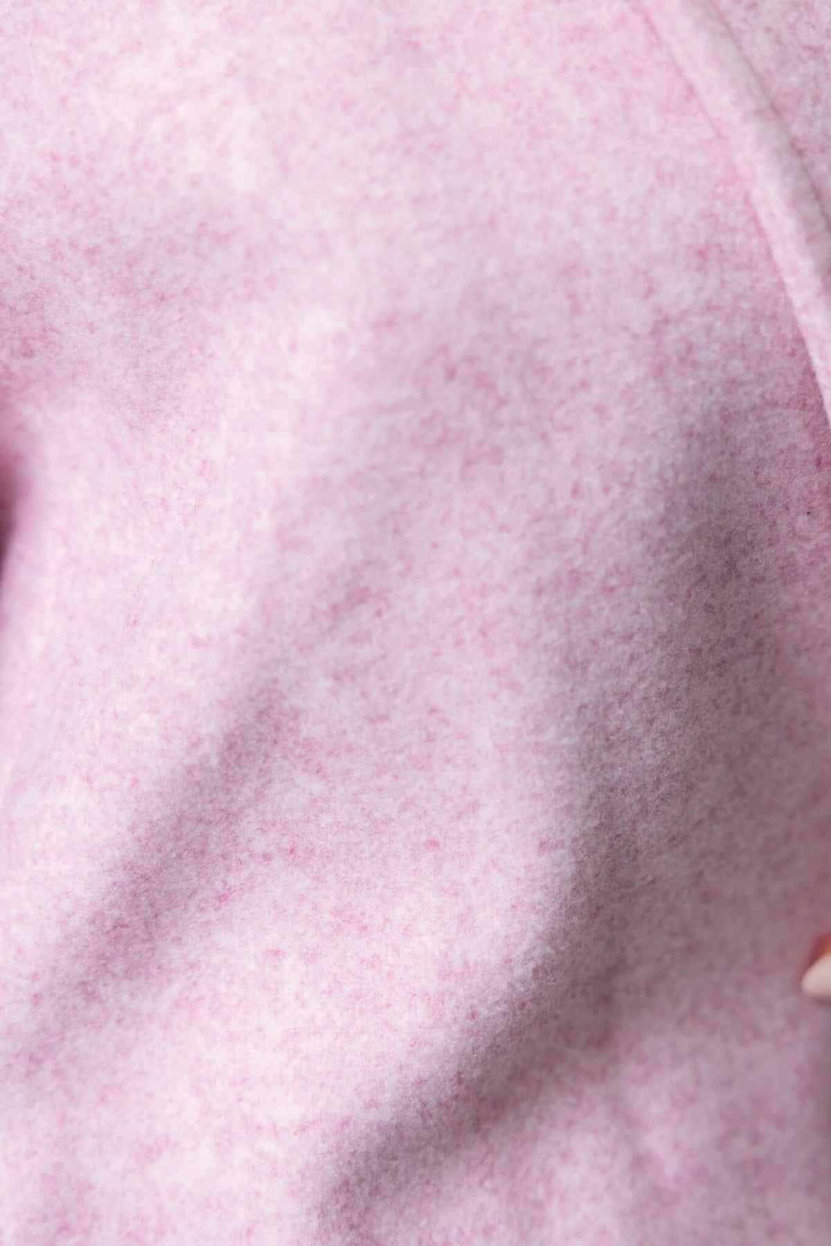 Close-up of soft pink fabric texture from Jensen Coat, highlighting its comfort and quality.