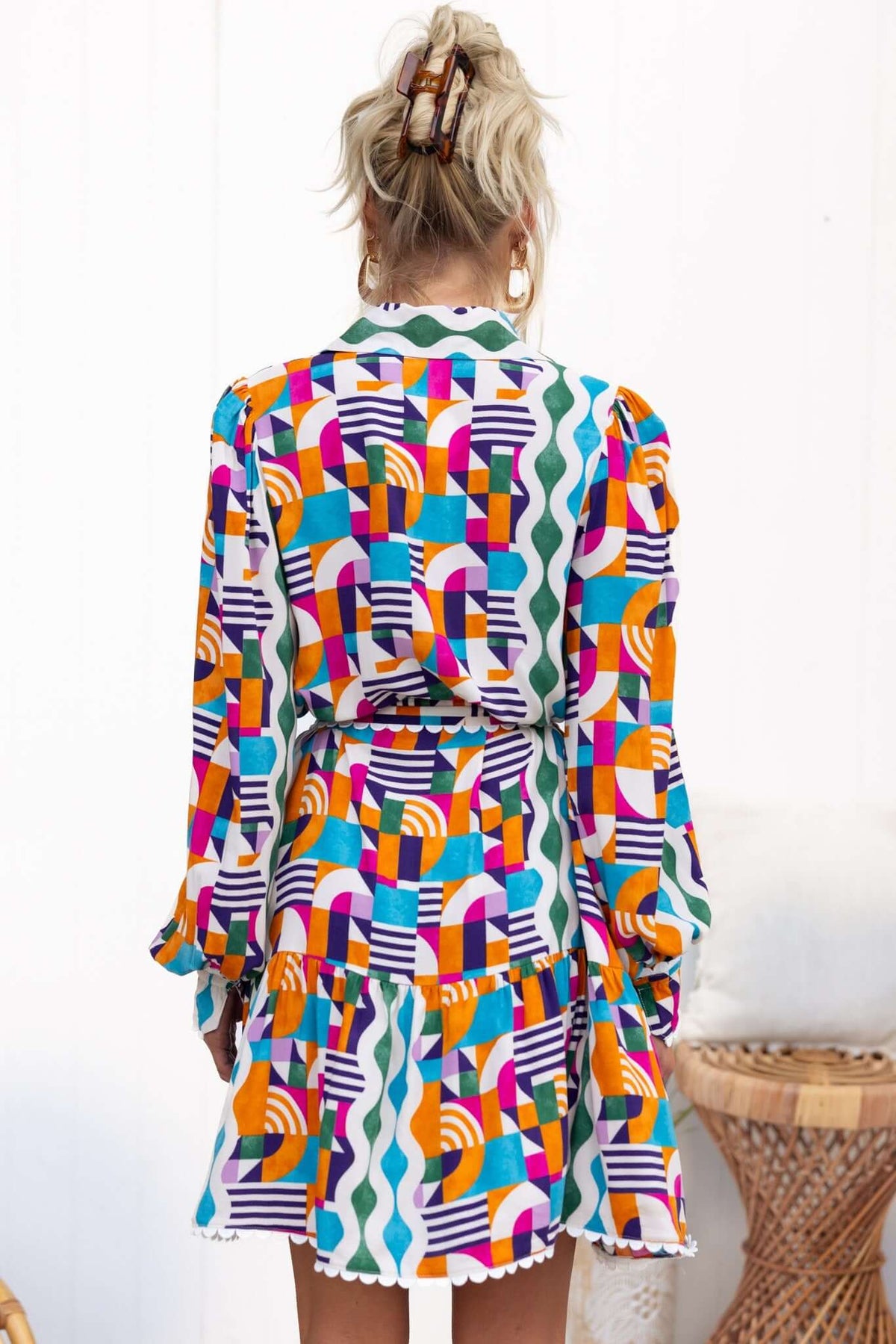 Back view of the Bransley Dress featuring a colorful geometric pattern and a removable tie detail.