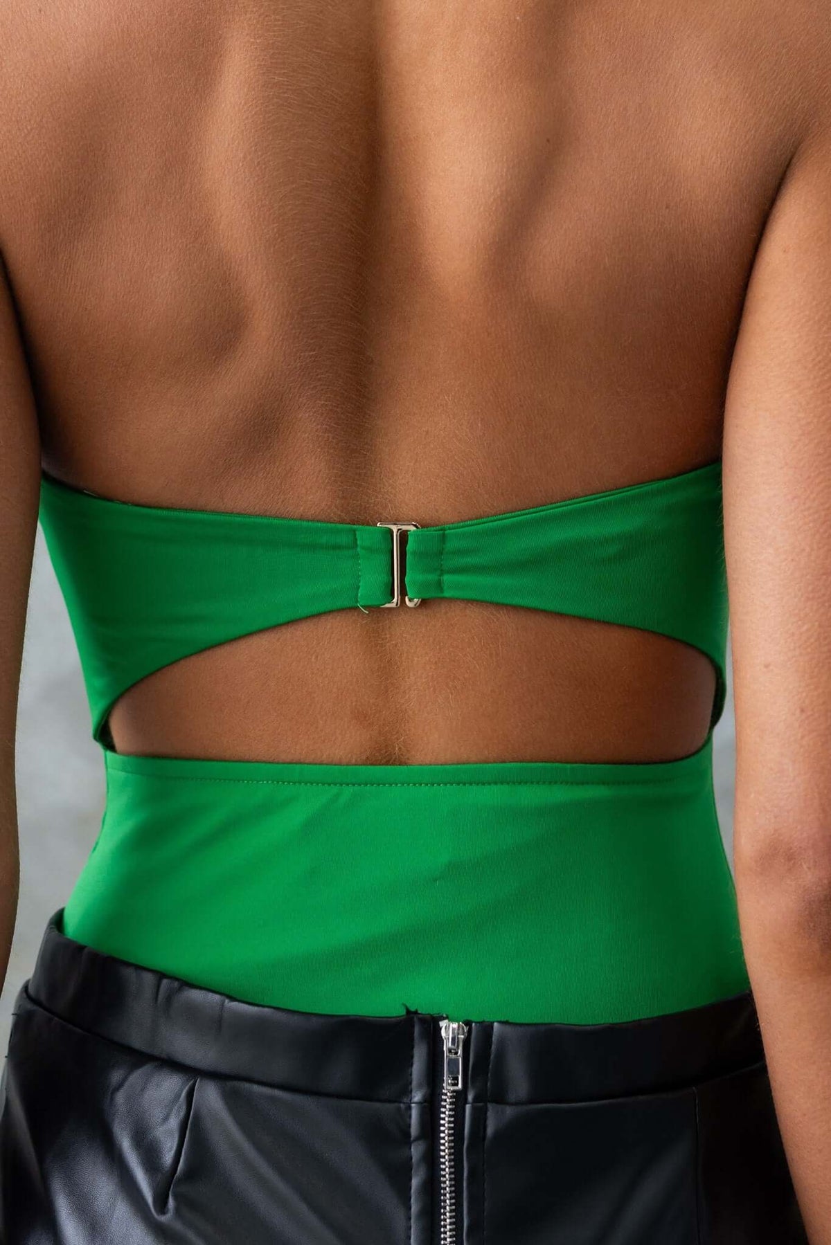 Close-up of the back of a green strapless bodysuit showing anti-slip bust and clasp detail.