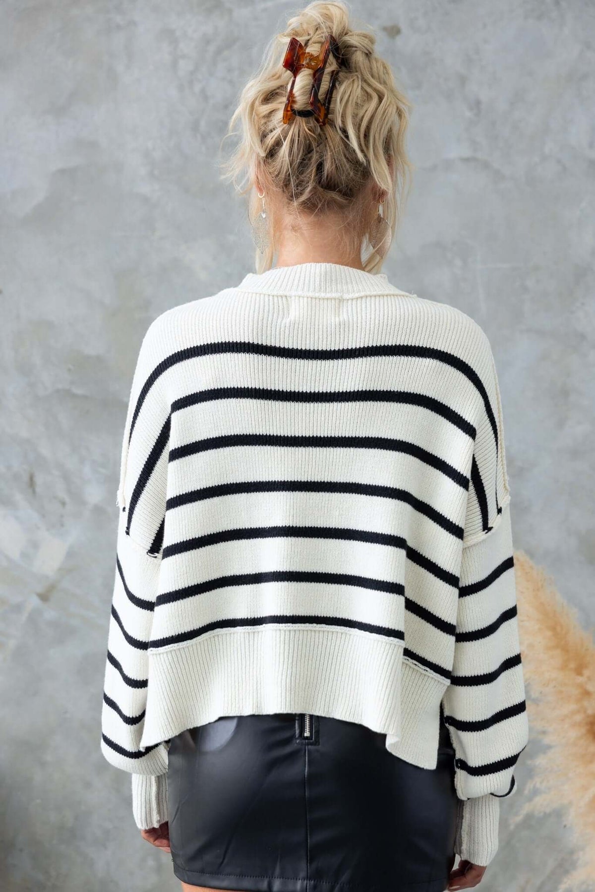 Back view of Pekin Jumper with mock neckline and side splits, featuring black stripes on a white knit material.