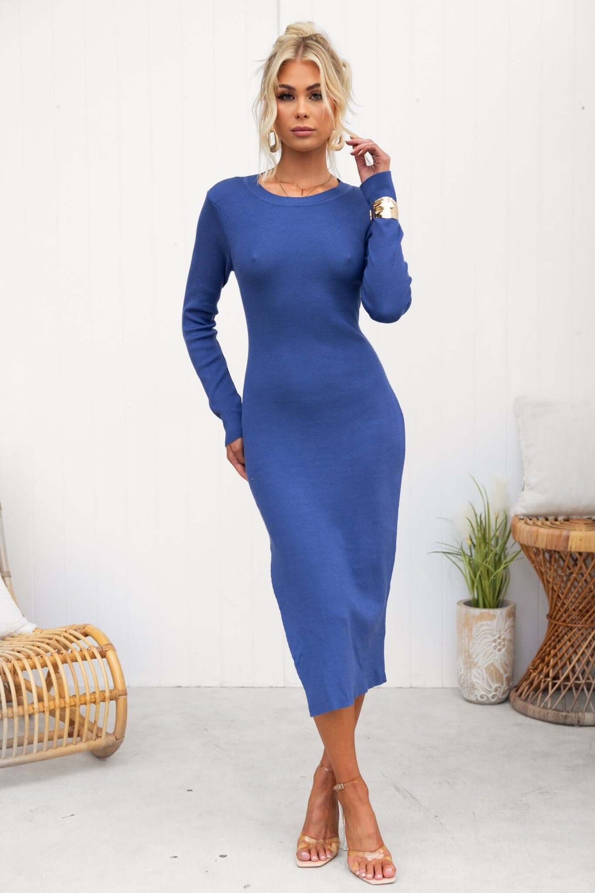 Blue ribbed midi dress with long sleeves and round neckline, featuring an open back and side split detail.