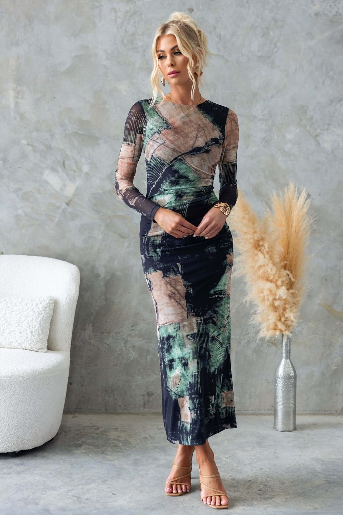 Model wearing Mystique Maxi Dress in abstract print, featuring long sleeves and a fitted silhouette, against a stylish backdrop.