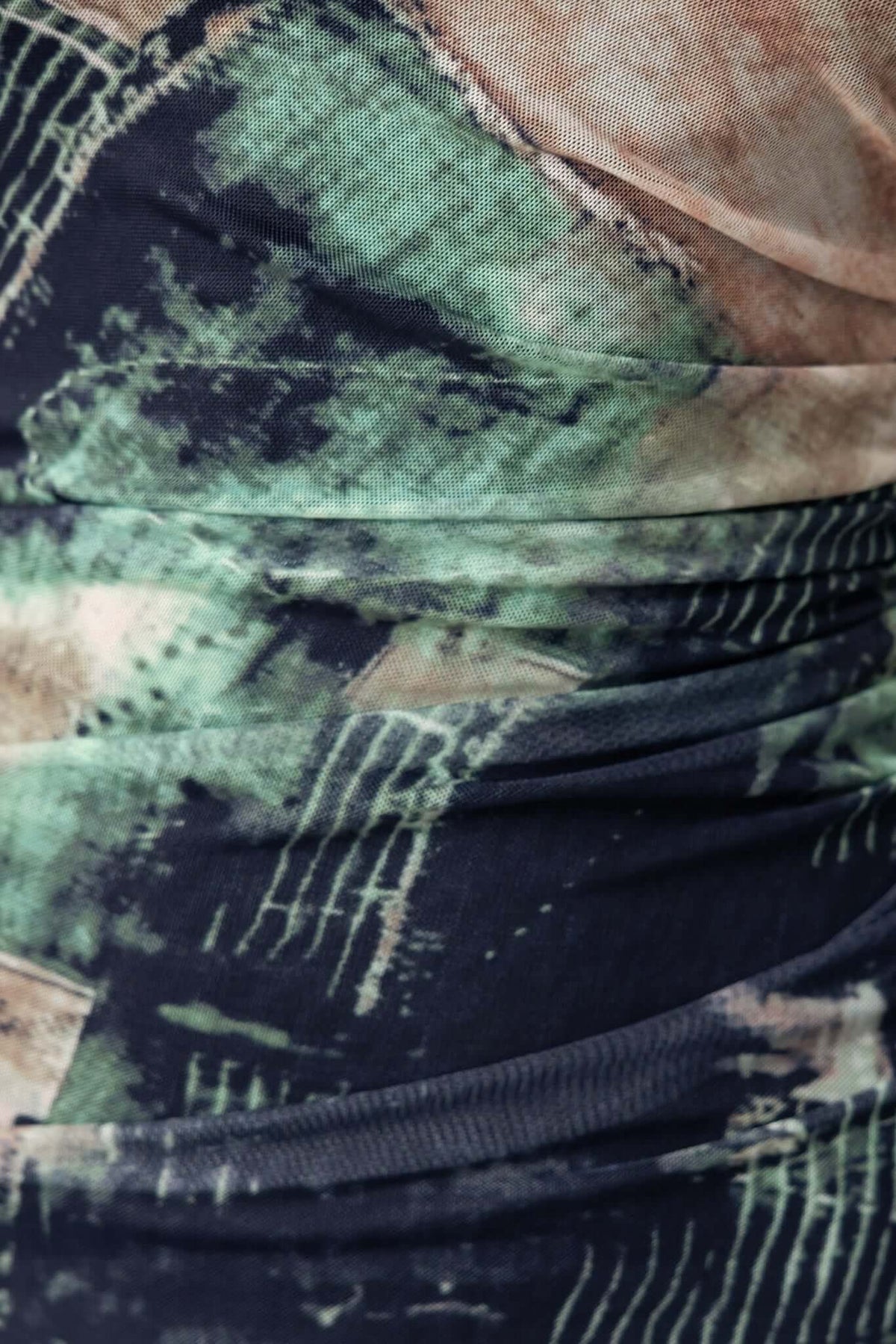 Close-up of the fabric texture of the Mystique Maxi Dress, showcasing abstract patterns in black and green.