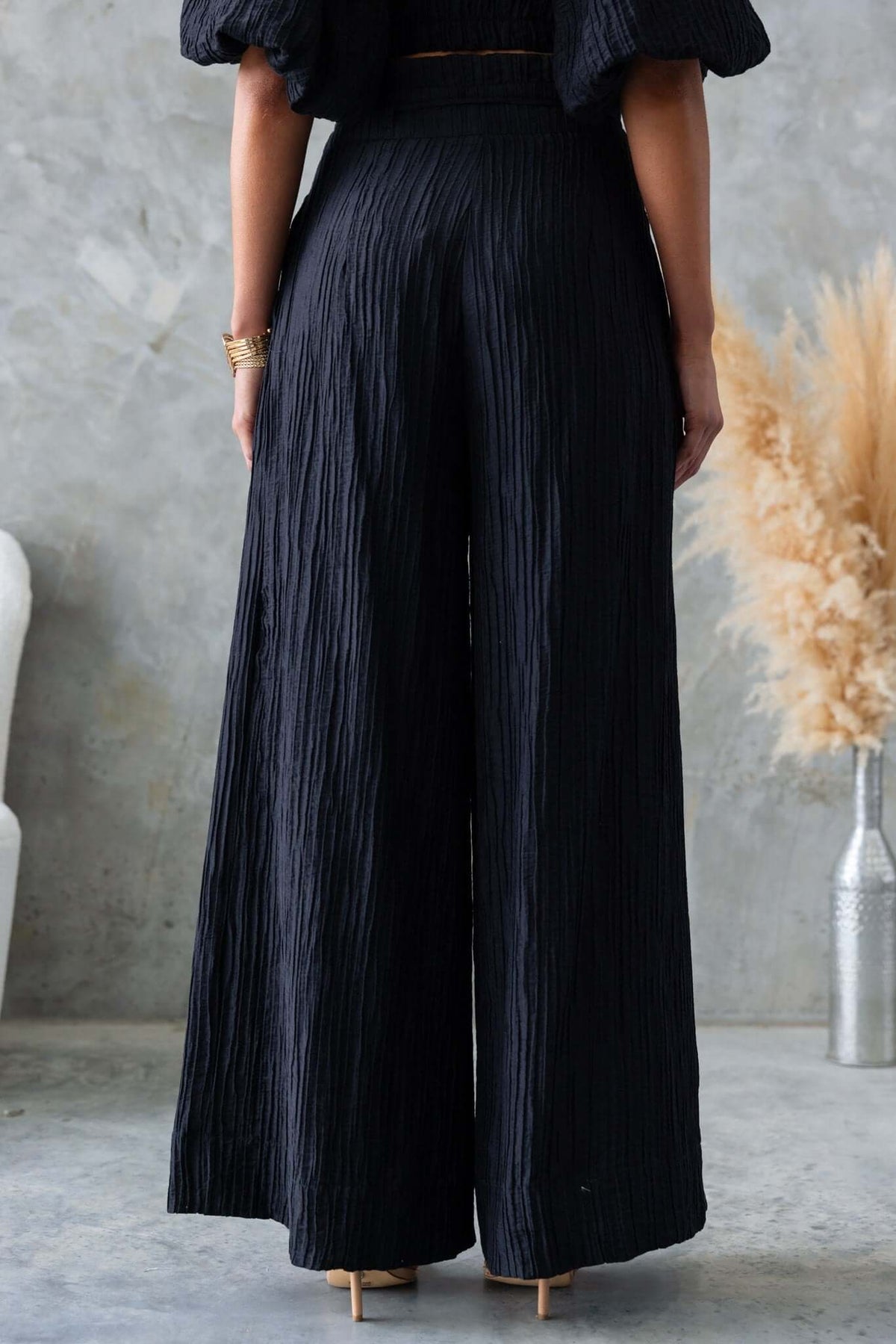 Back view of textured black Know Better Pants with mid-high waist and wide-leg design.
