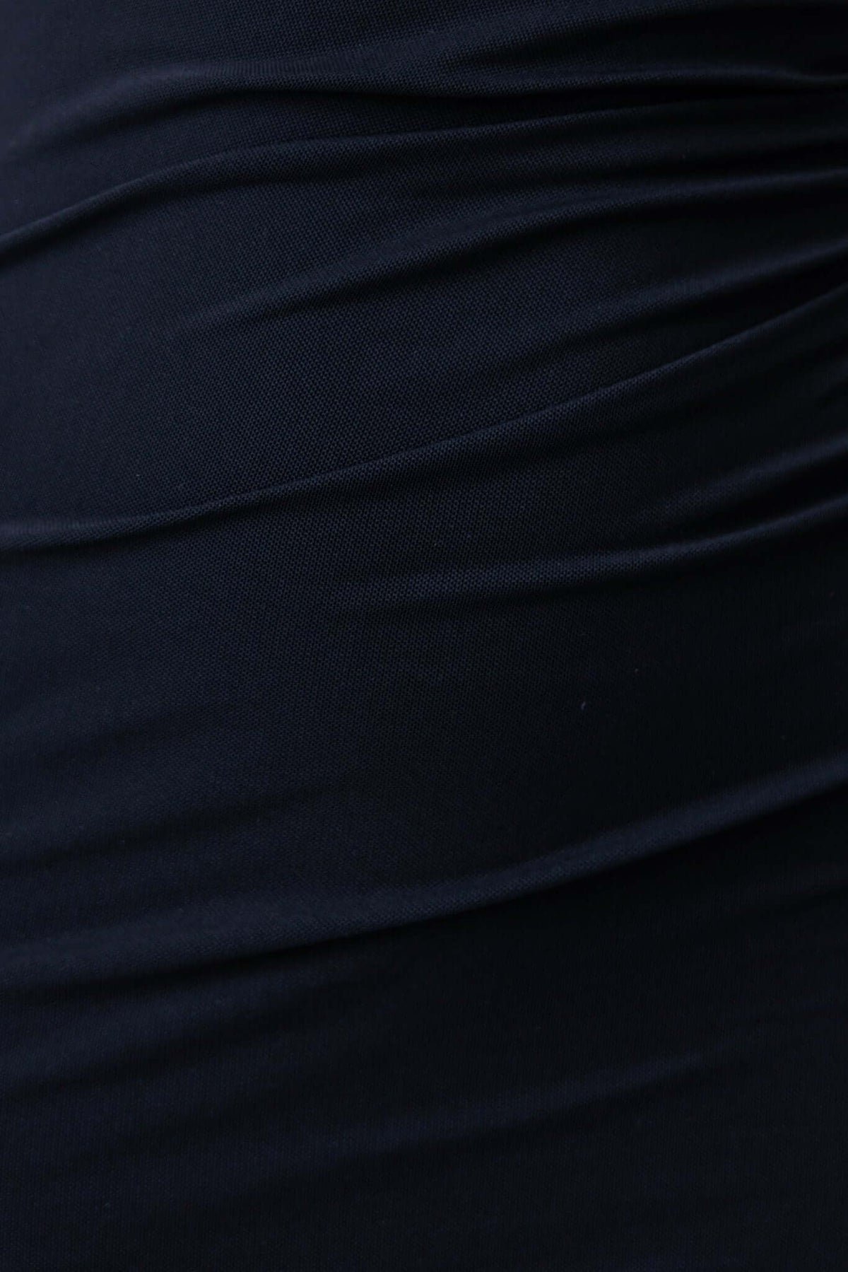 Close-up of textured black fabric showcasing ruching detail from the Mystique Maxi Dress.