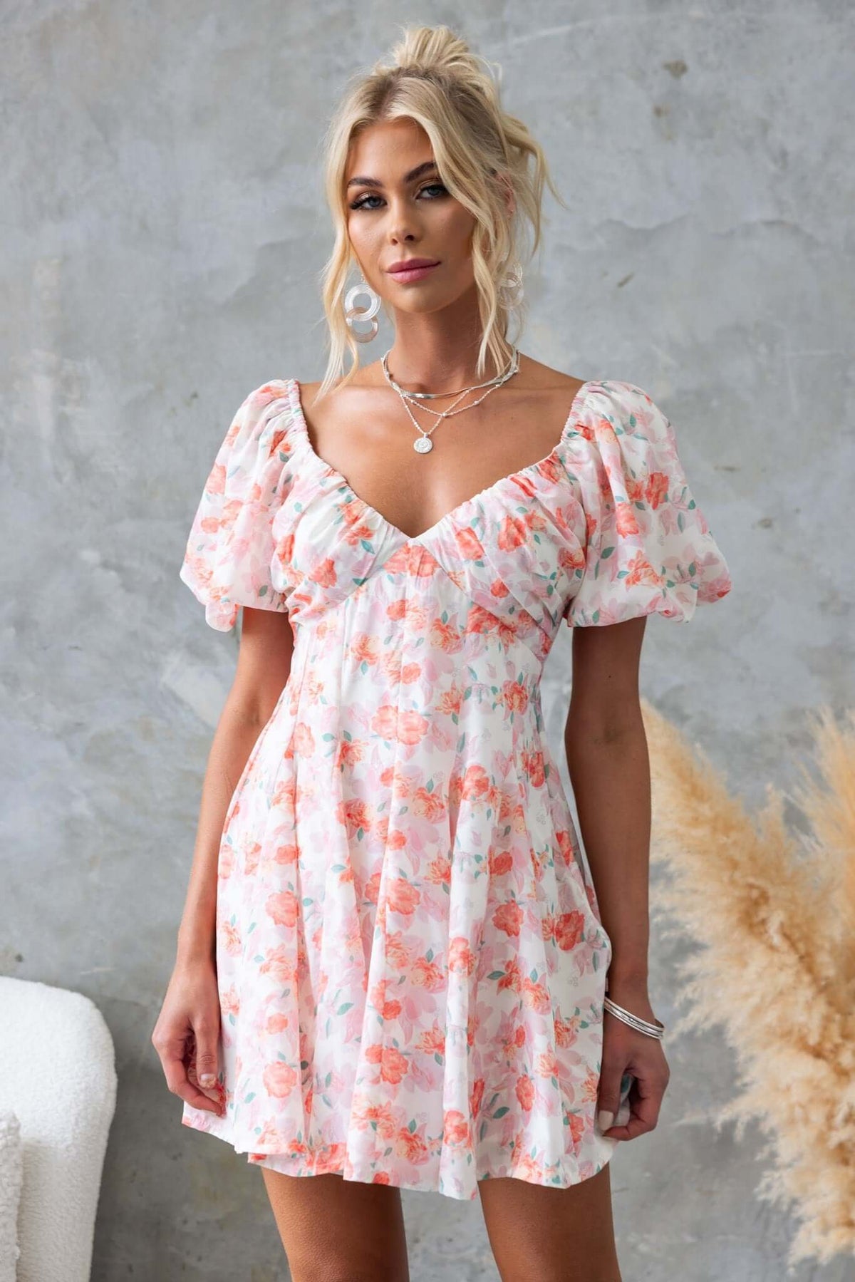 Woman in floral Feel Good Dress with puff sleeves and a low-cut back, perfect for casual outings.