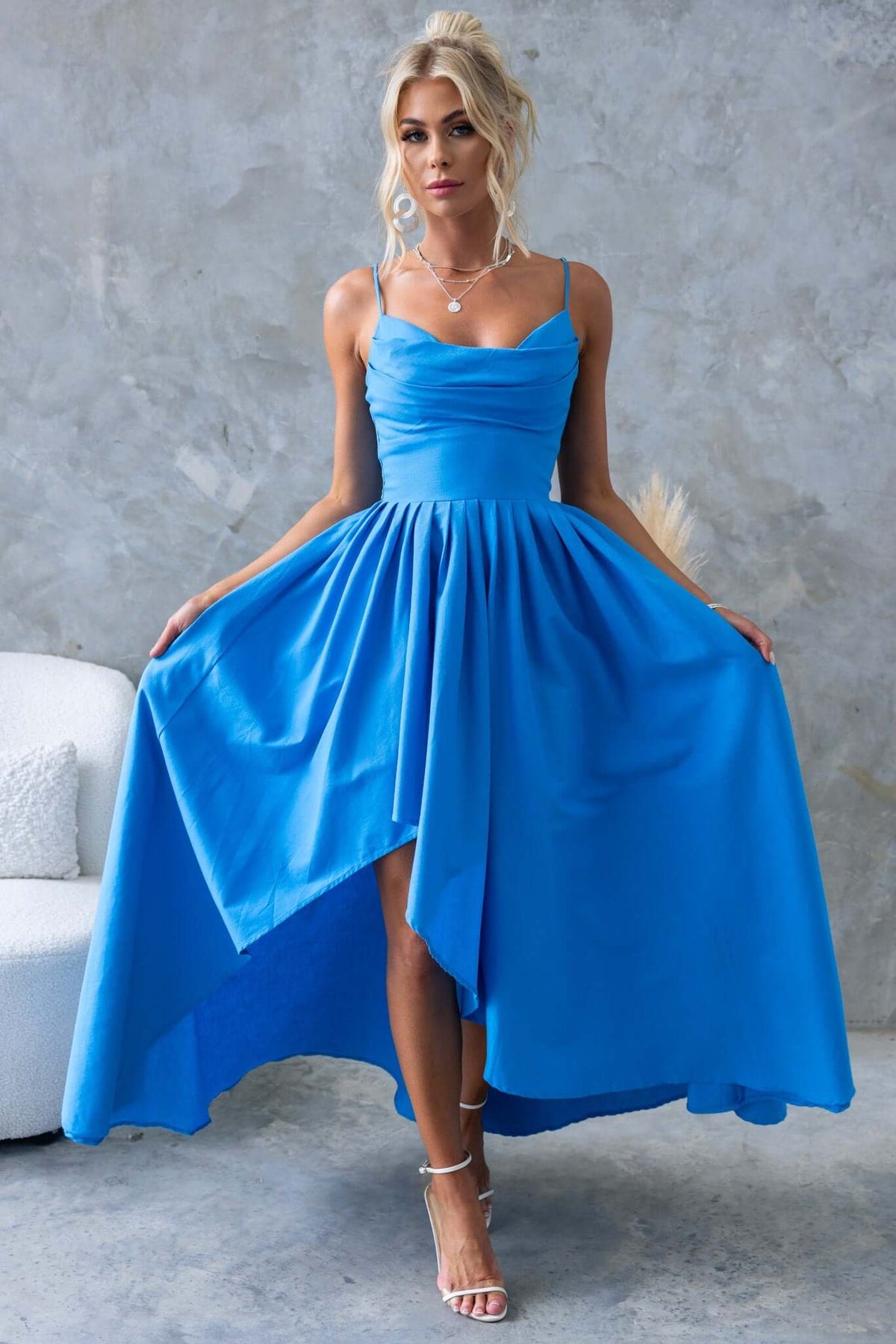 Model wearing a blue Adalita Maxi Dress with adjustable straps and asymmetrical hemline in a stylish indoor setting.