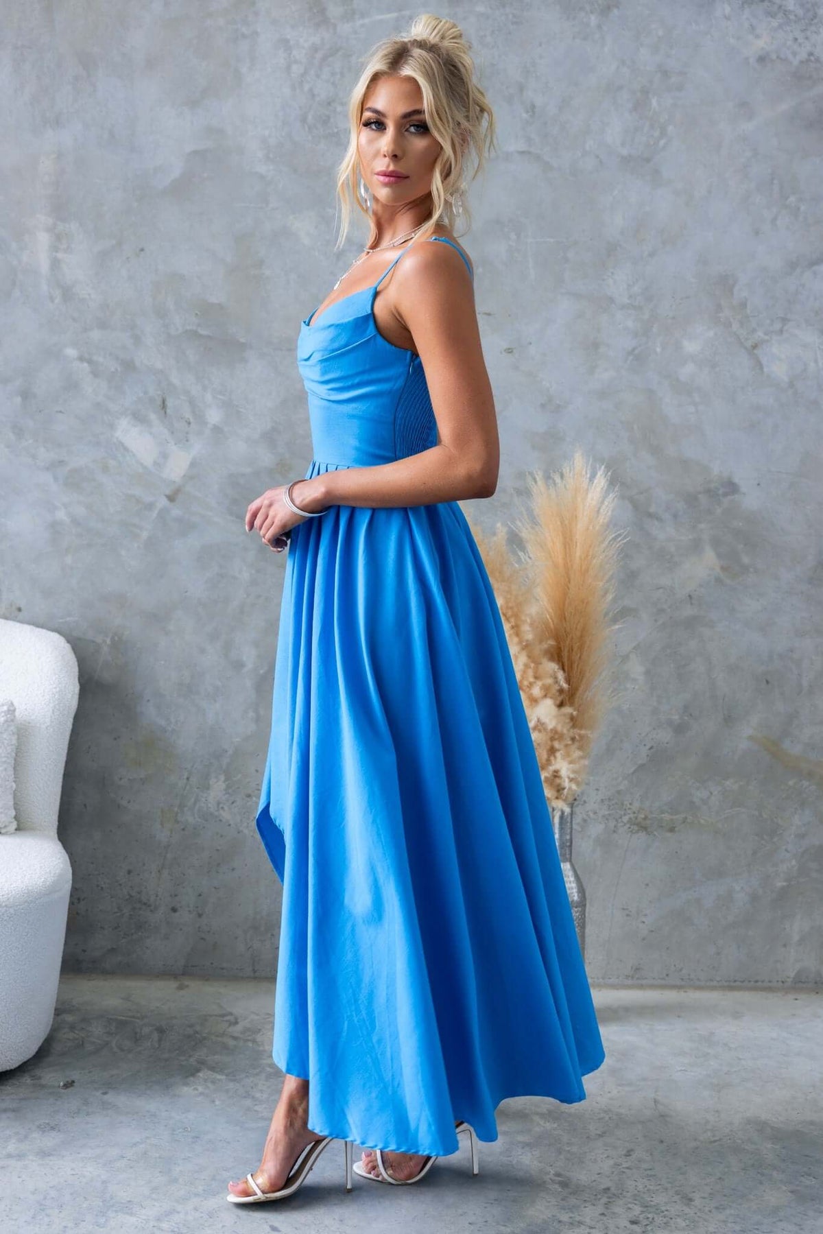 Model wearing a blue Adalita Maxi Dress with adjustable straps and an asymmetrical hemline.