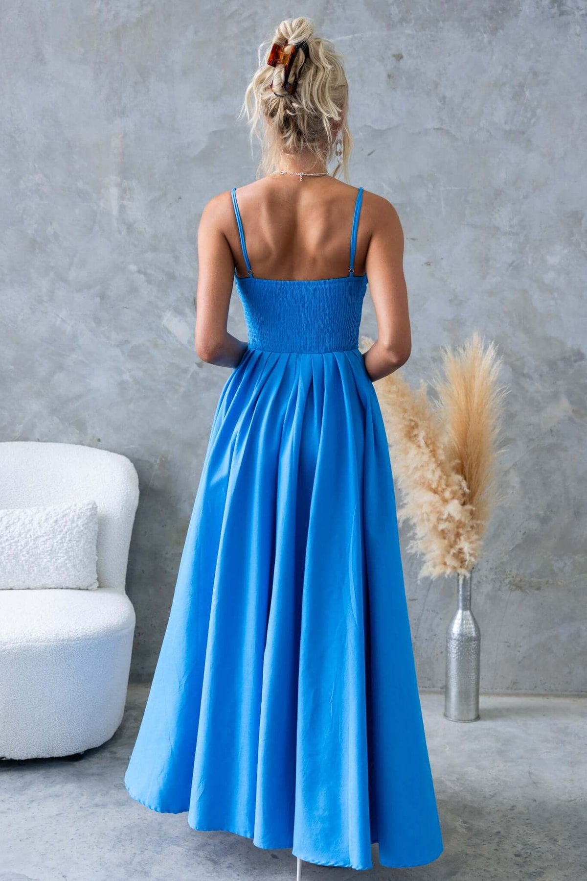 Back view of Adalita Maxi Dress in vibrant blue, featuring adjustable straps and flowing asymmetrical hemline.
