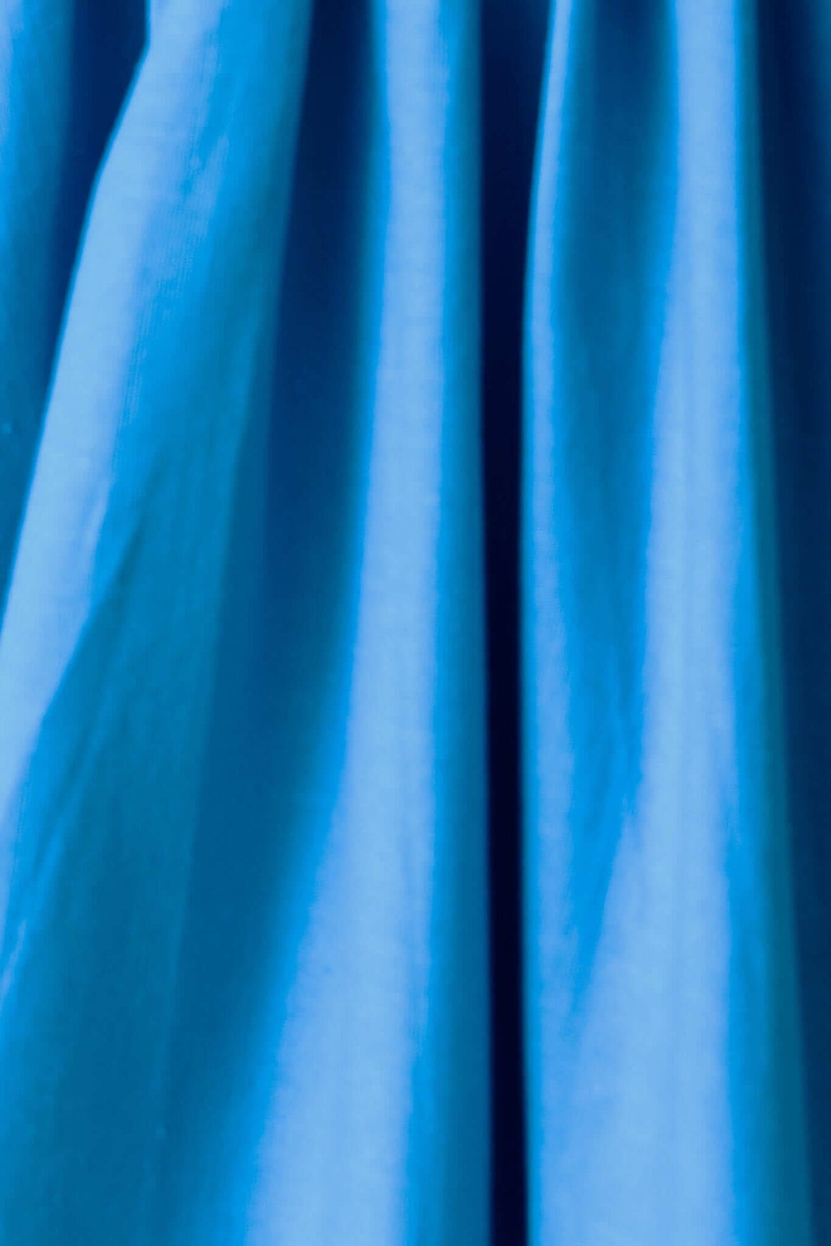 Close-up of bright blue fabric featuring gentle folds, showcasing texture and color for Adalita Maxi Dress.