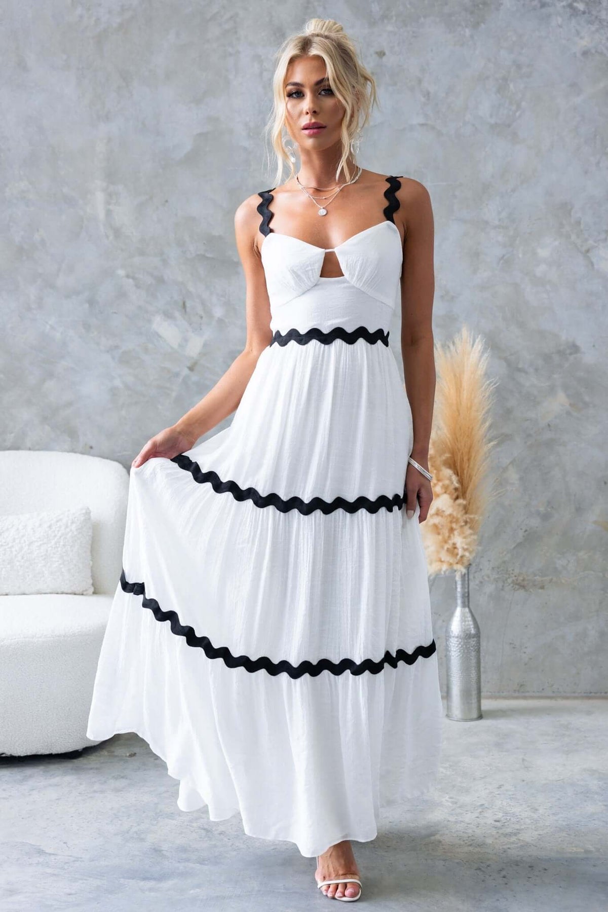 Elegant Qaia Maxi Dress with adjustable straps and cut-out at bust, featuring black trim details.