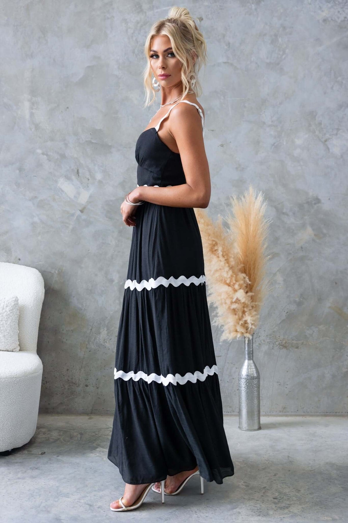 Stylish black Qaia maxi dress with adjustable straps and cut-out detail, perfect for summer events.