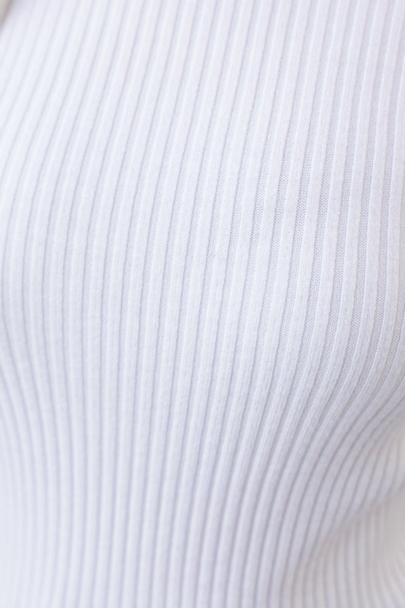 Close-up of Zoma Top in ribbed knit material, showcasing its high neckline and stretch fabric design.
