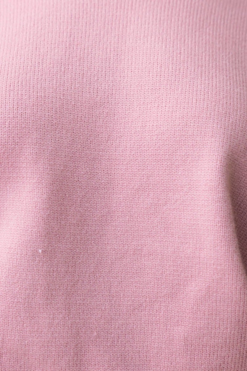 Close-up of a soft pink ribbed knit fabric, showcasing the texture of the Verny Jumper.