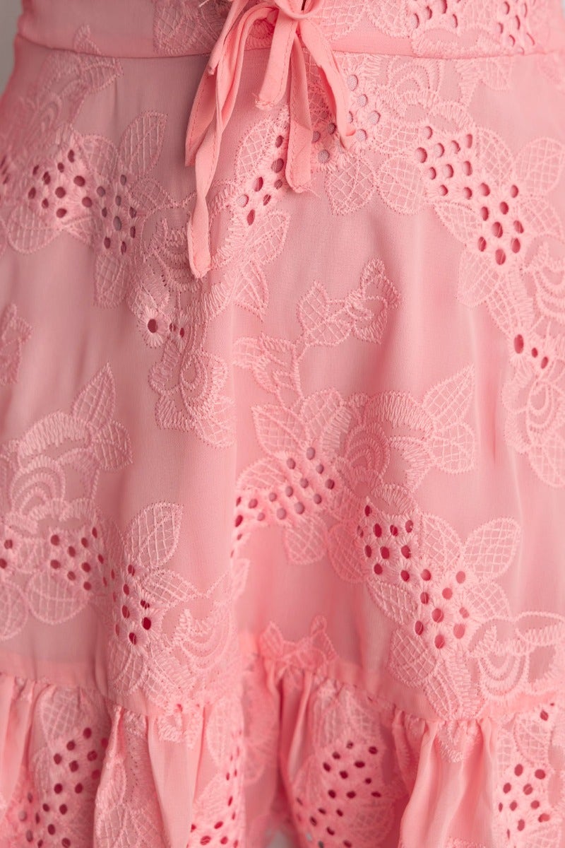 Close-up of the Pinolo Dress in pink Anglaise material, featuring detailed floral embroidery and tie waist detail.