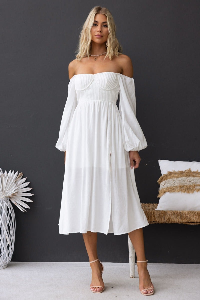 Model wearing a white Lost Love Midi Dress featuring off-shoulder design, pleat detail, and a front split.