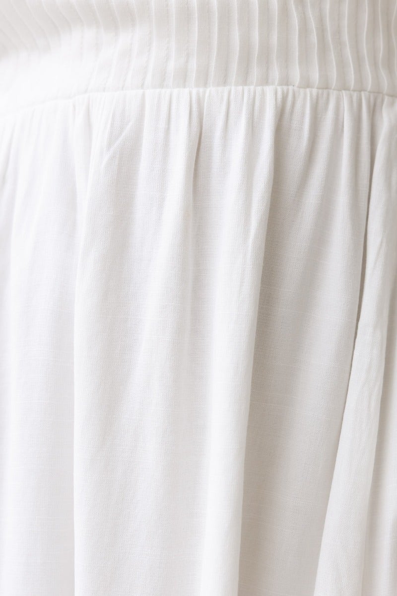 Close-up of the fabric detailing on the Lost Love Midi Dress, showcasing pleat and elastic design in soft white cotton blend.