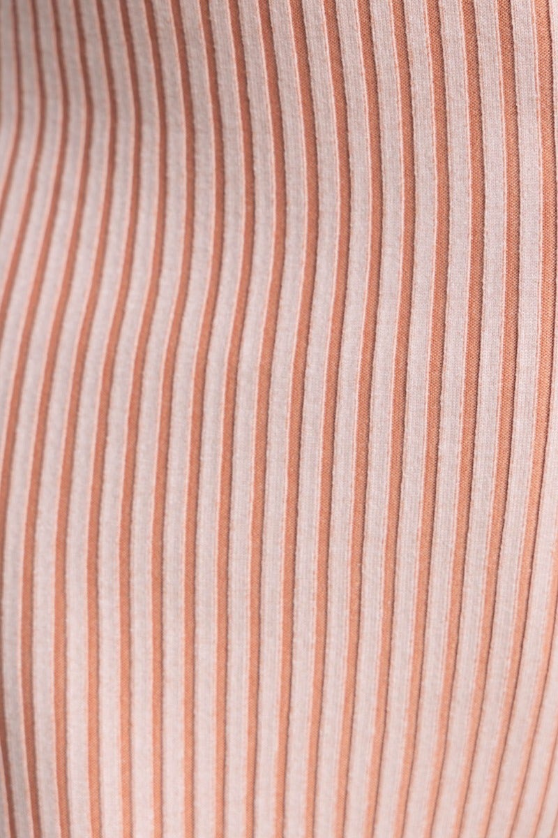 Close-up of ribbed knit fabric in peach and cream stripes, showcasing texture ideal for a stylish midi skirt.