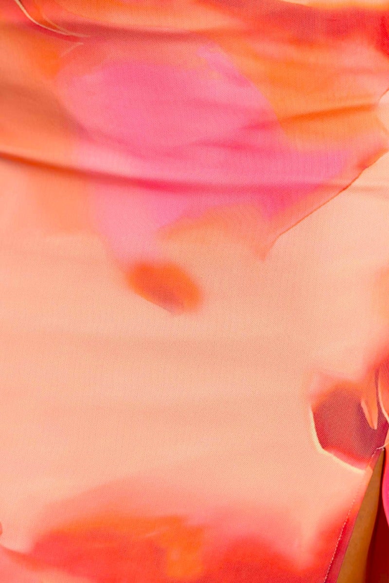 Close-up of a vibrant mesh fabric in shades of pink and orange, showcasing the smooth texture and color blend.