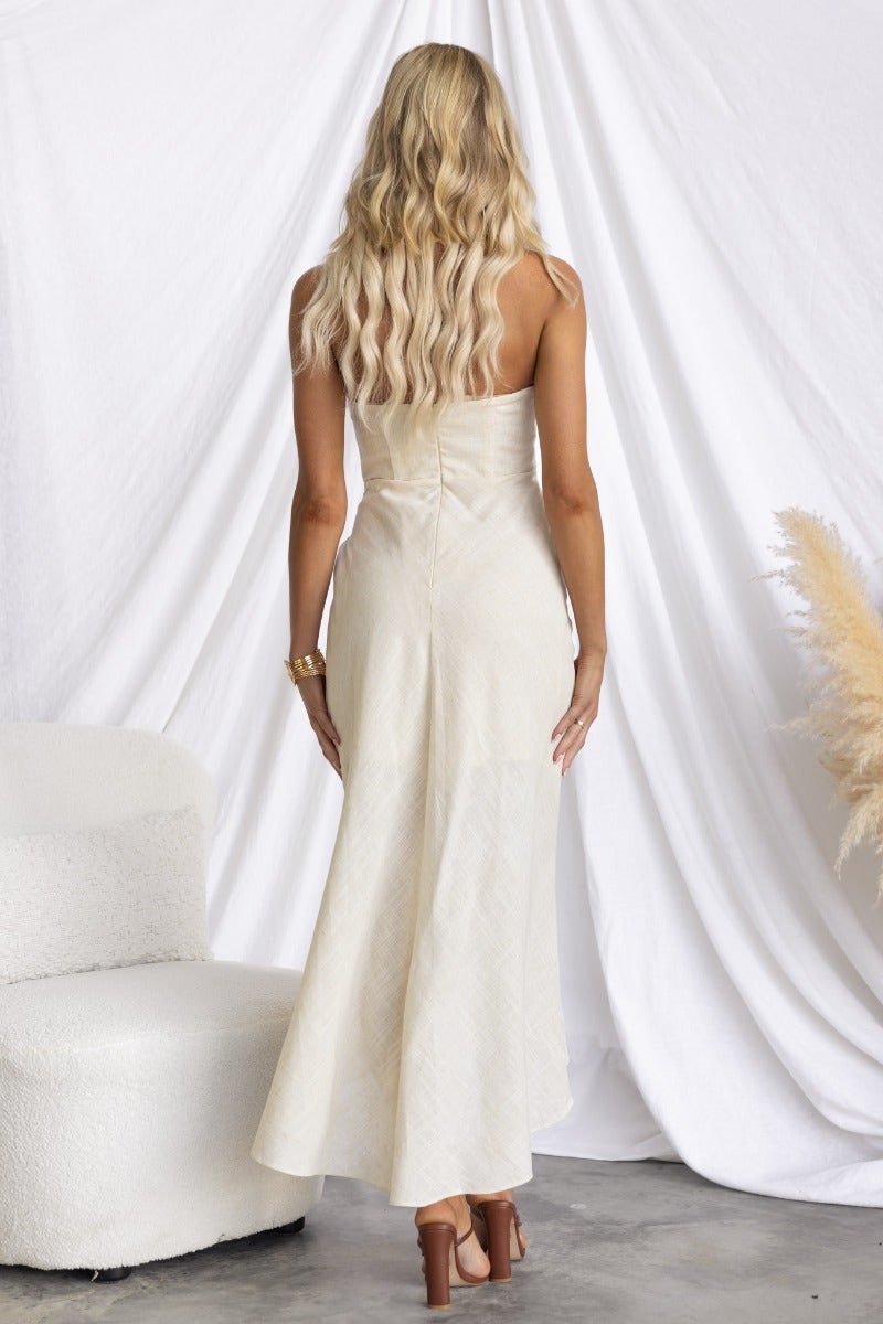 Woman wearing a strapless linen blend Gala Midi Dress, showing the back view with a wrap skirt and subtle details.