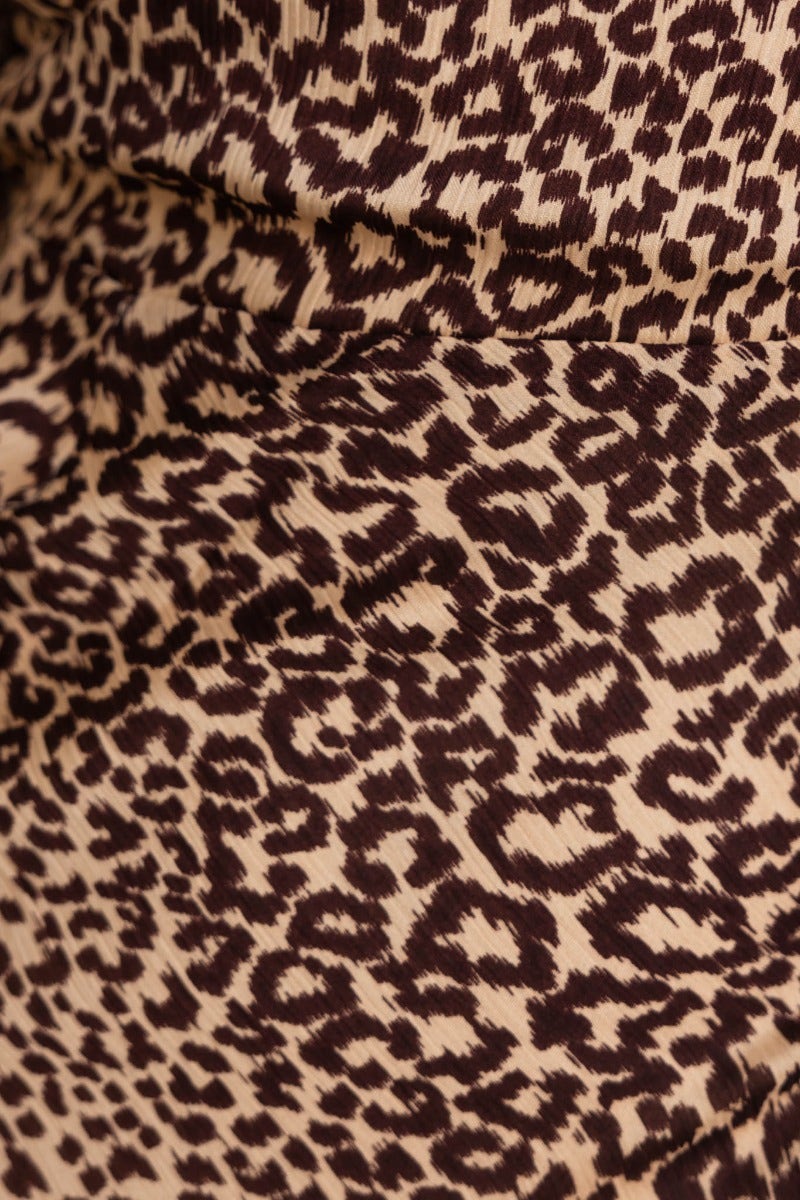 Close-up of animal print fabric featuring a cream background with dark brown leopard spots, ideal for a stylish midi dress.
