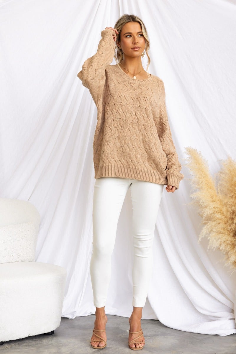 Renee Jumper in cable knit style, featuring a relaxed fit, round neckline, and worn with white pants.