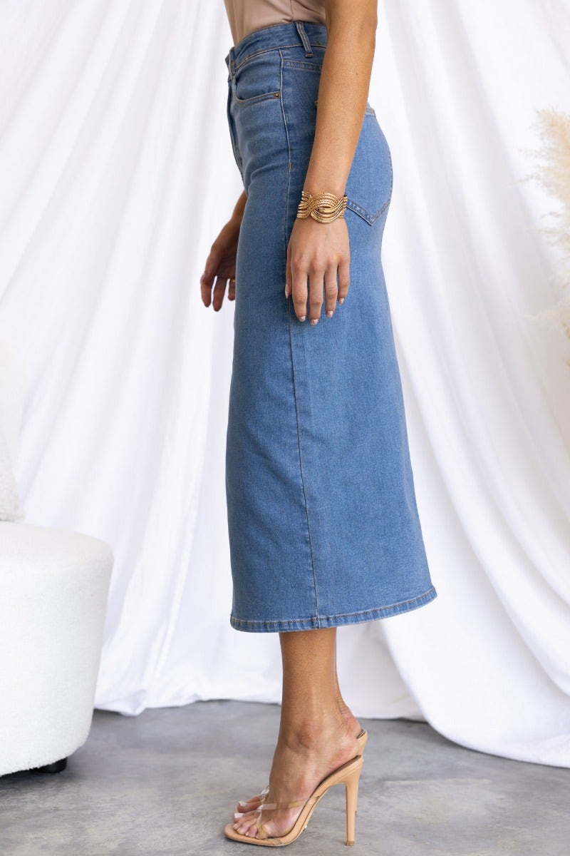 Side view of Evelyn Denim Midi Skirt featuring a mid-high waist, pockets, and a stylish front split.