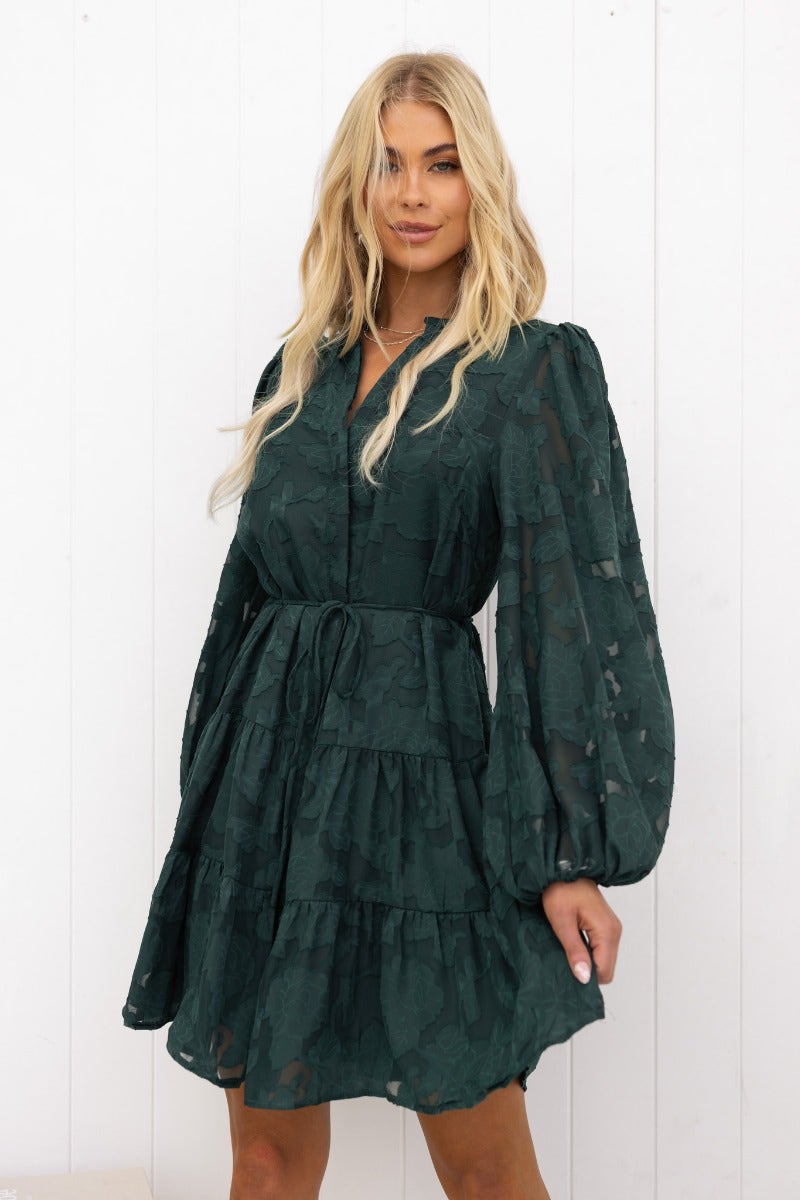 Model showcasing a Halston Dress featuring embossed print, button-up front, and removable tie in dark green.