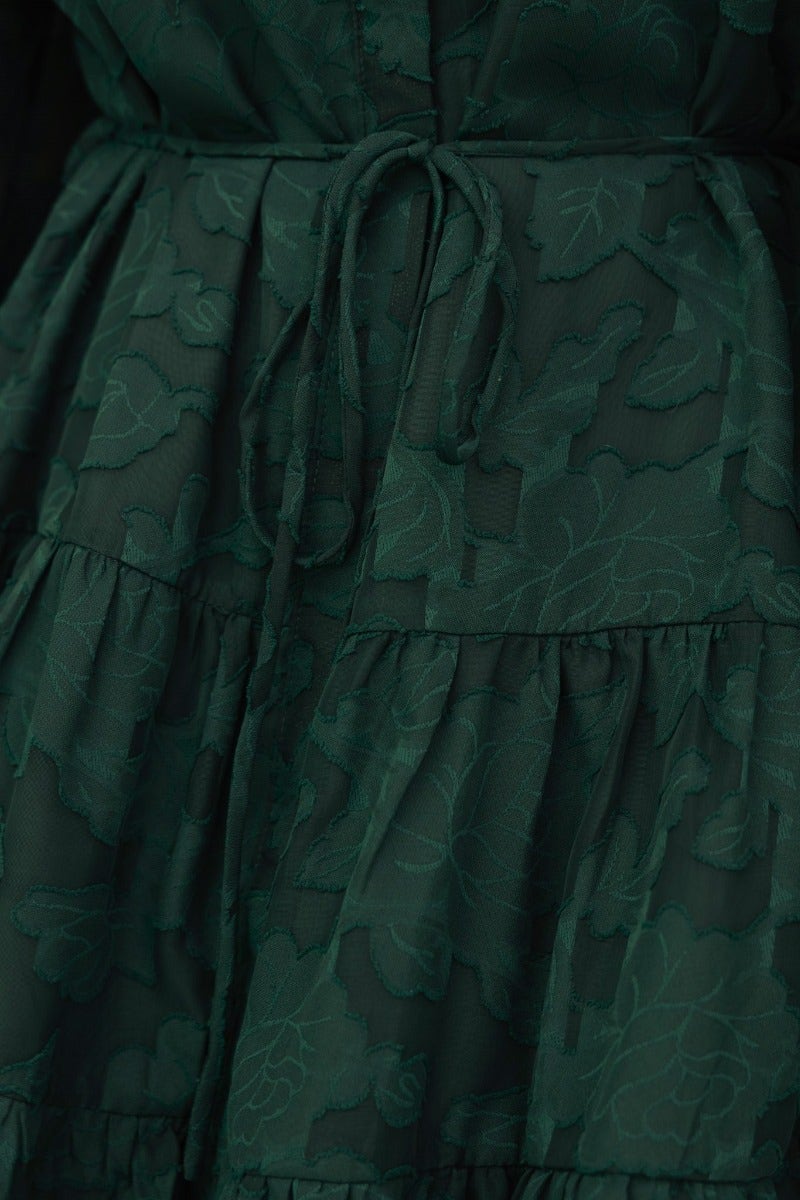 Close-up of the Halston Dress featuring an embossed floral print and fabric tie detail.